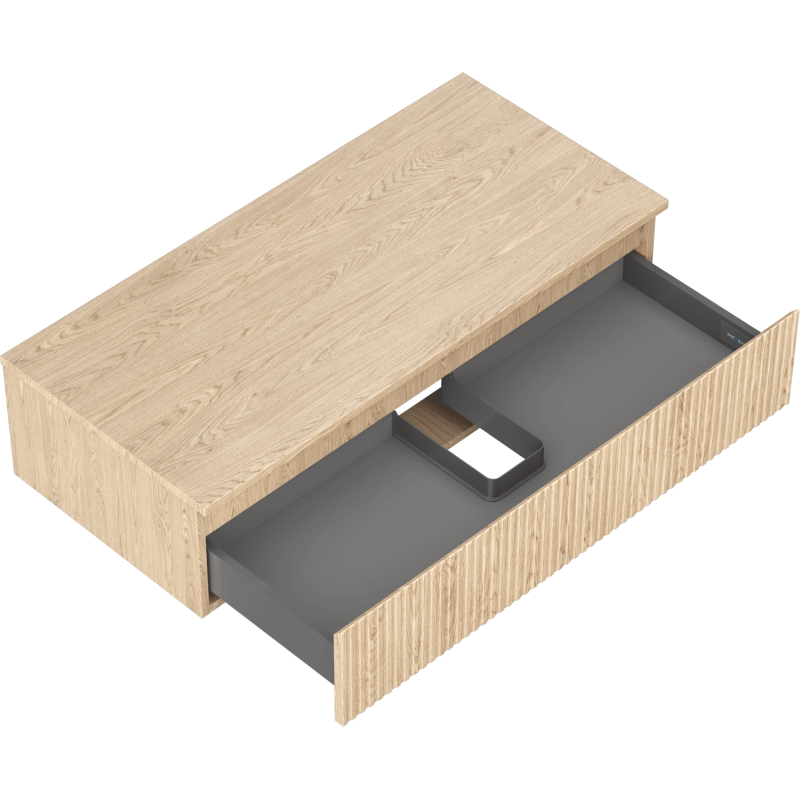 Servantskap uten vask i lys eik med åpen grå innerskuff og utsparing for rør, sett skrått ovenfra.