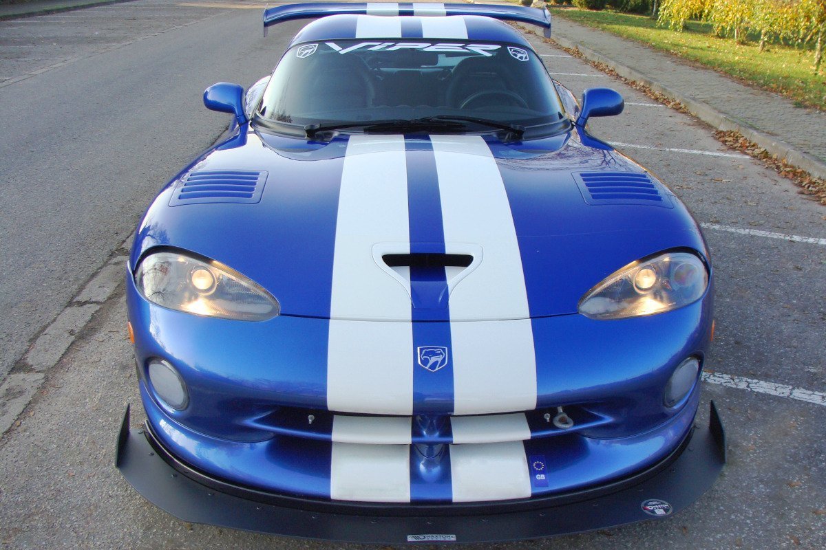 Frontspoiler på blå Dodge Viper GTs med hvite striper, store frontlykter og synlig bakspoiler.