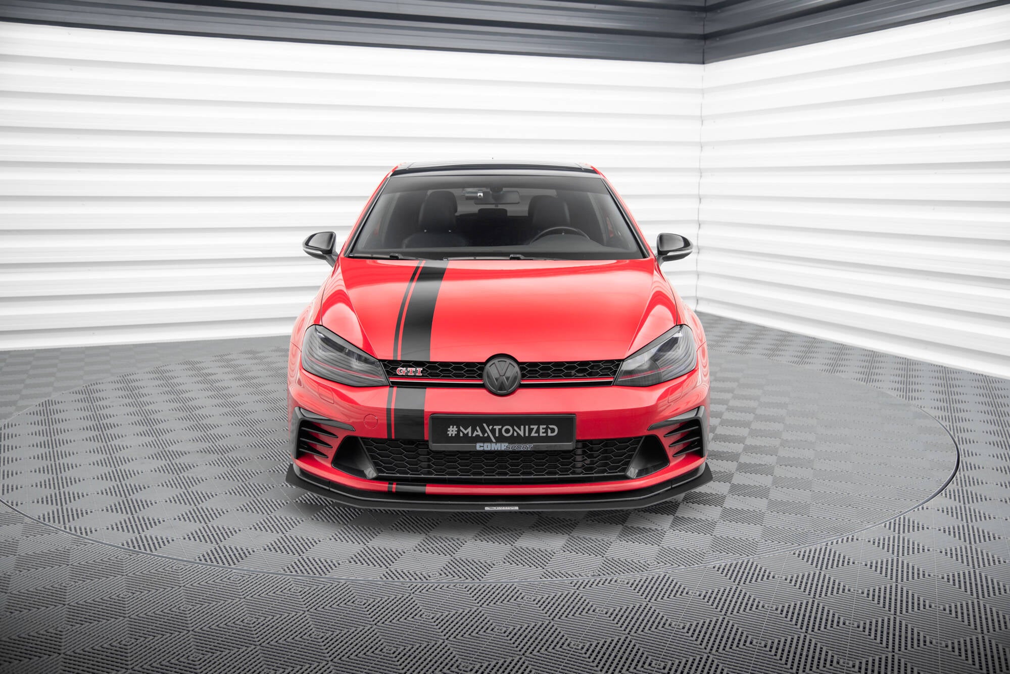 Frontleppe på VW Golf VII GTI Clubsport med svart racingstripe og sportslig frontsplitter i lyst studio.