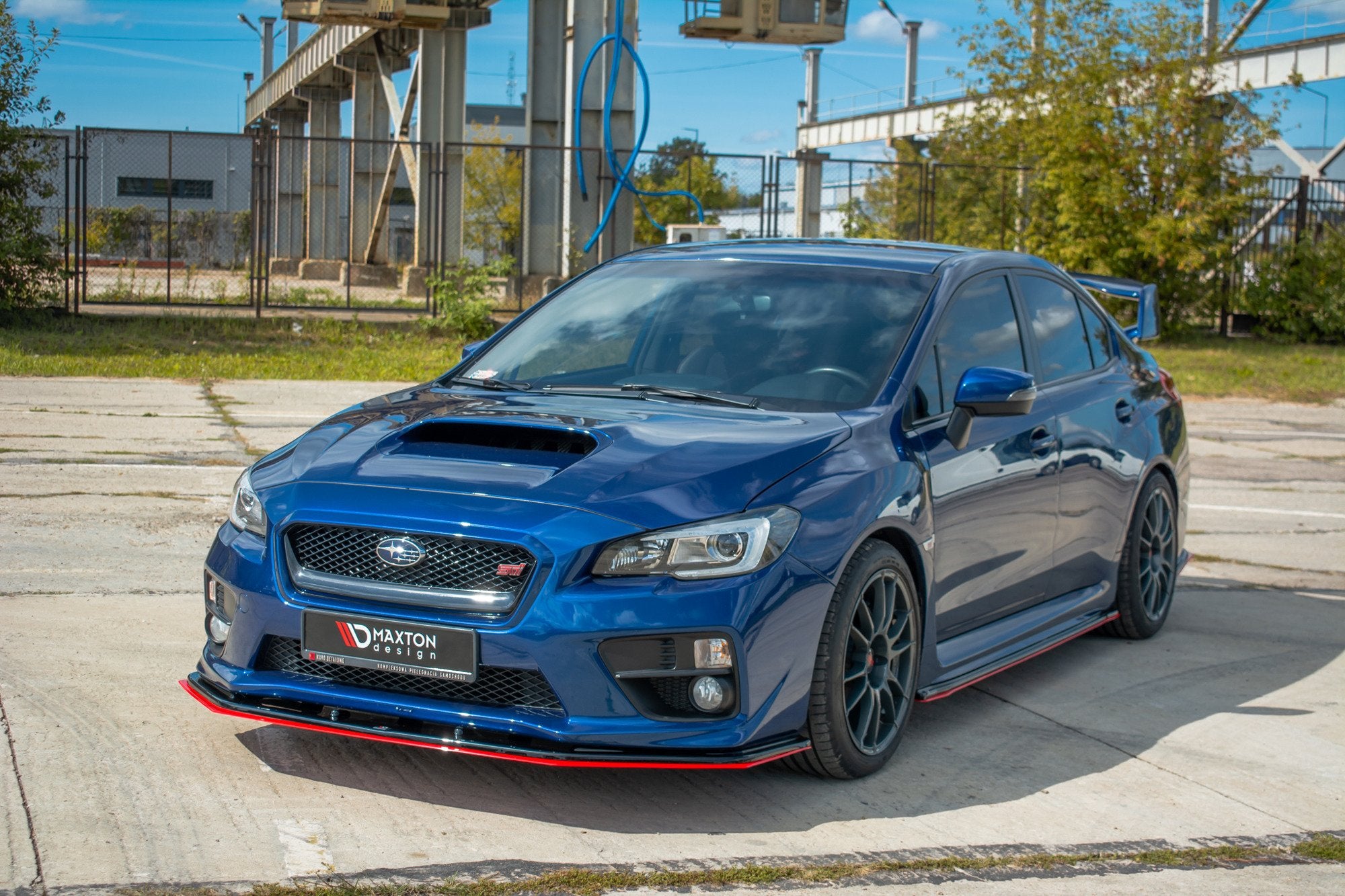 Frontleppe Subaru WRX Sti V.4 med sort og rød splitter, store felger og sotede vinduer sett forfra.