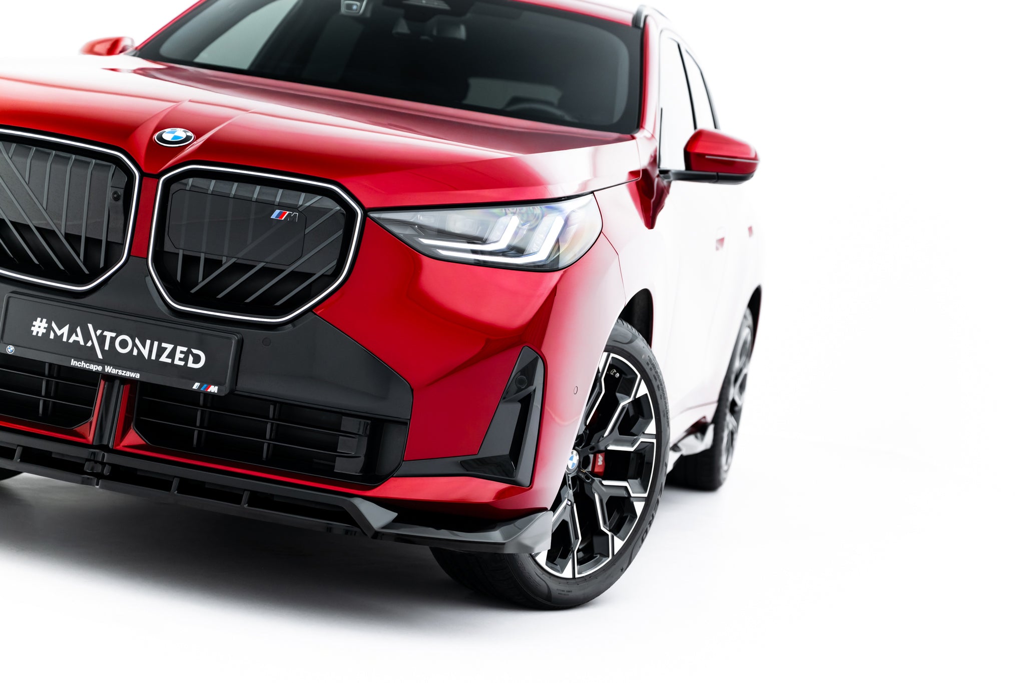 Spoiler på BMW X3 M-Pakke G45, rød bil skrått forfra med synlig frontgrill, hovedlykt og felg.