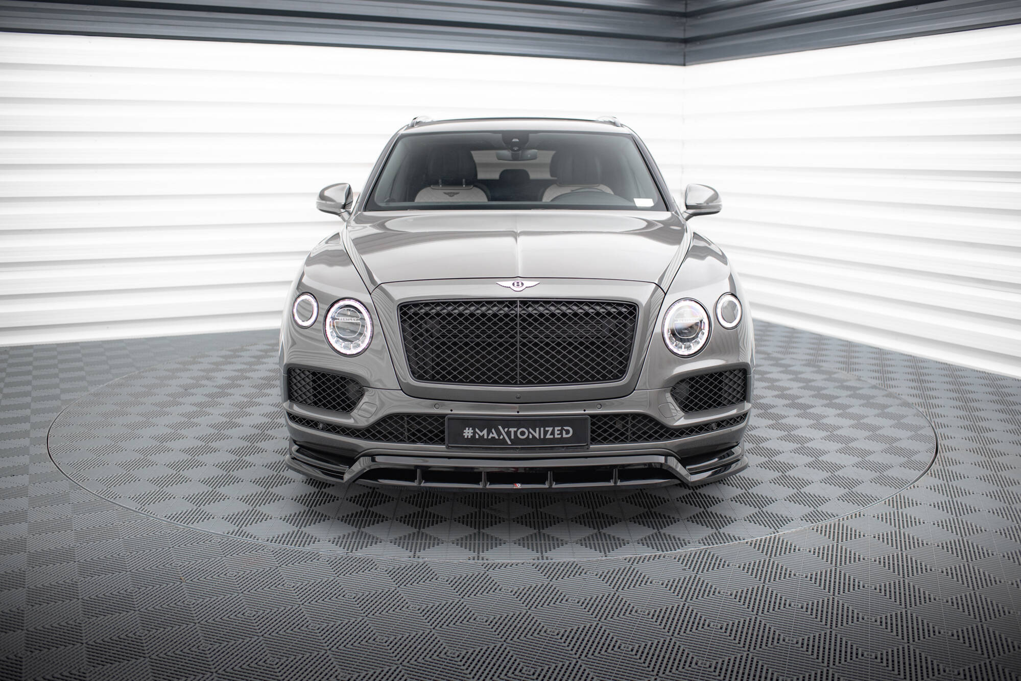 Frontleppe på Bentley Bentayga MK1 SUV i grå metallic med sort grill og runde LED-lykter foran.
