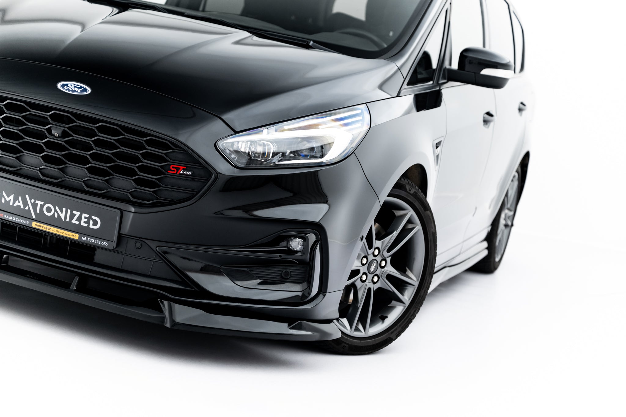 Front lip på Ford S-Max ST-Line MK2 Facelift med svart grill, LED-lys og sølvfelg sett skrått forfra.