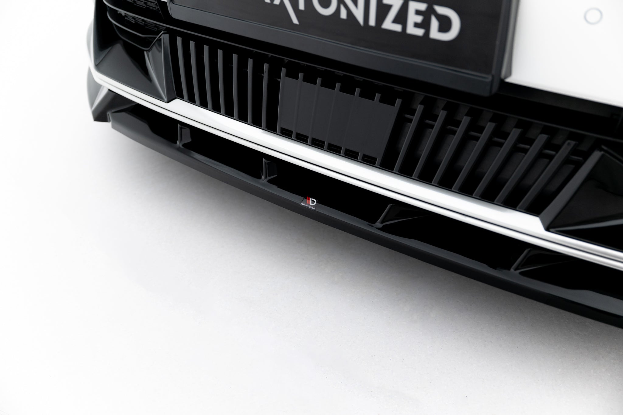 Spoiler til Kia Ev6 MK1 vist som nærbilde av svart bilgrill med blanke detaljer og kantet design.