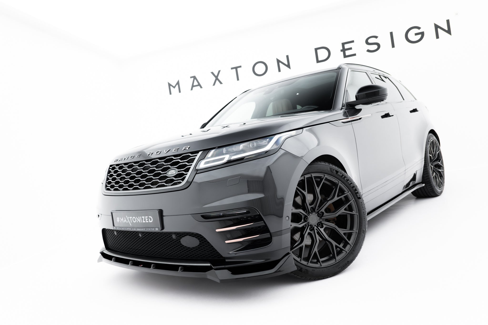 Spoiler på Land Rover Range Rover Velar R-Dynamic MK1 i mørk grå med sorte felger i lyst studio.