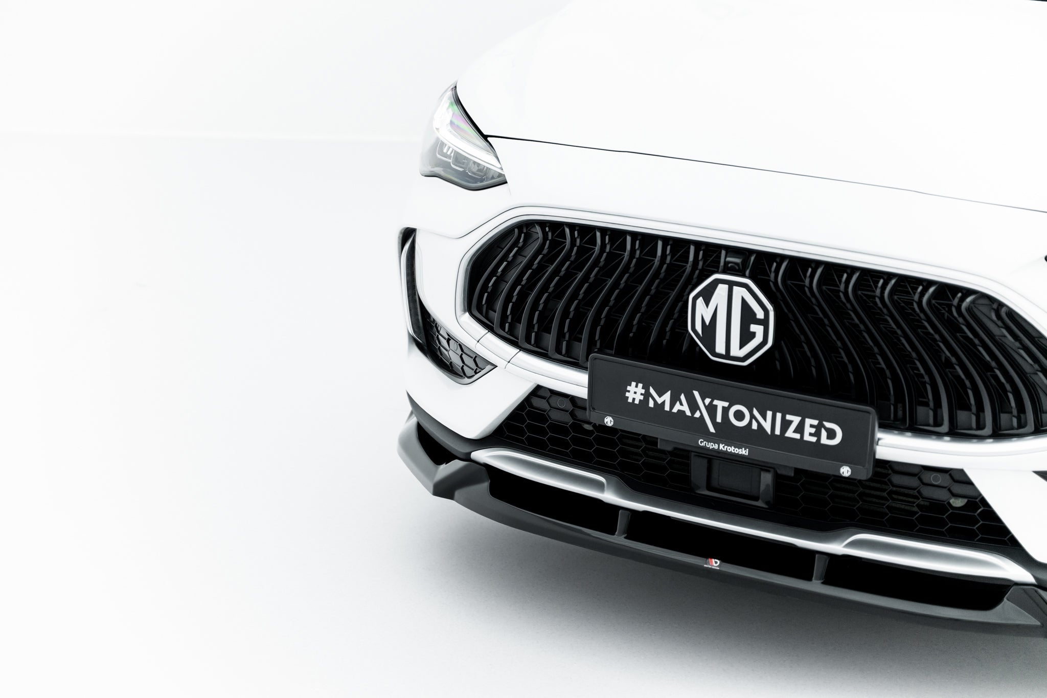 Front splitter på MG HS MK1 Facelift med sort grill, MG-logo og skiltet #MAXTONIZED foran.
