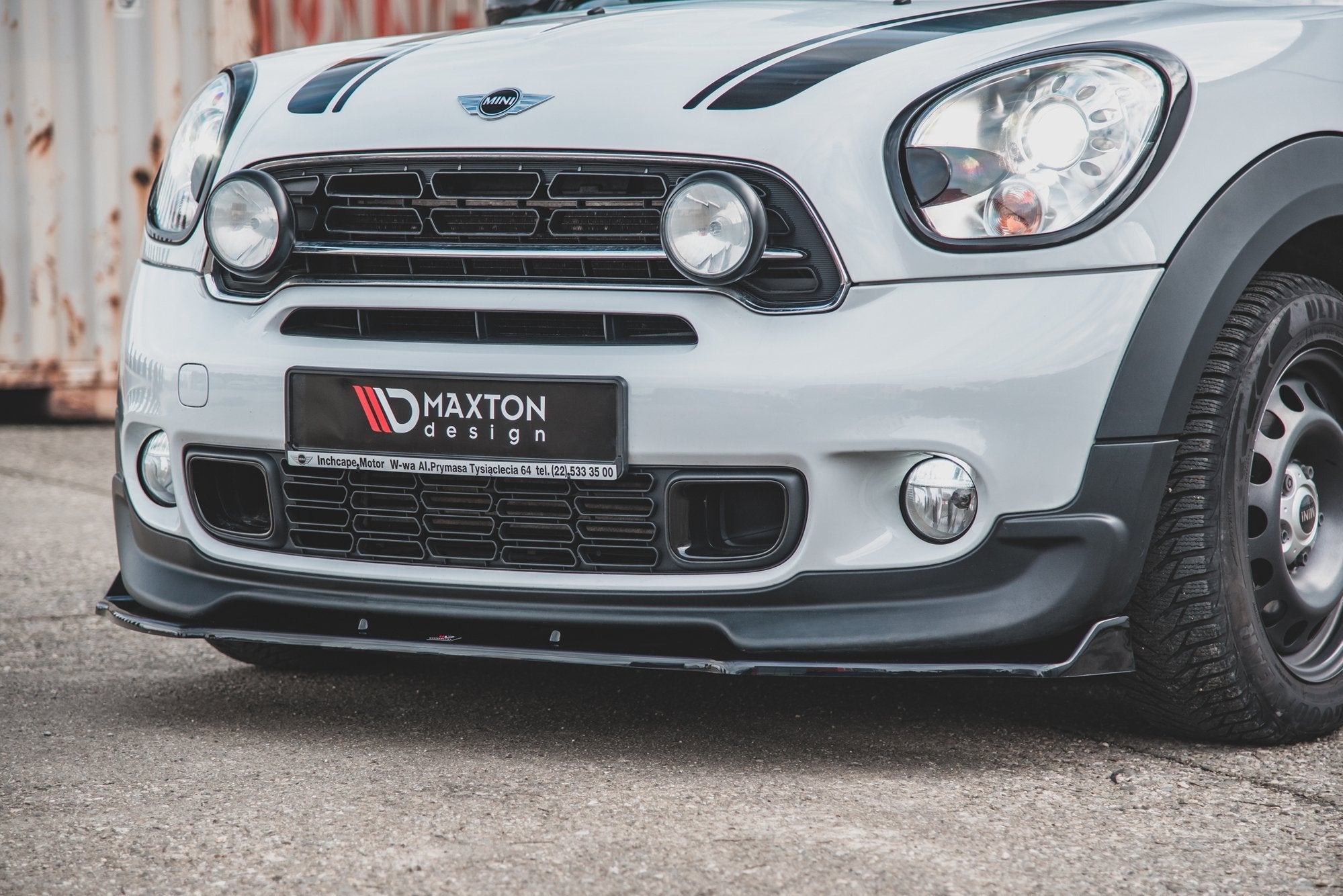 Front splitter til Mini Countryman MK1 Jcw montert på hvit bil med sorte detaljer, sett i skrå vinkel.