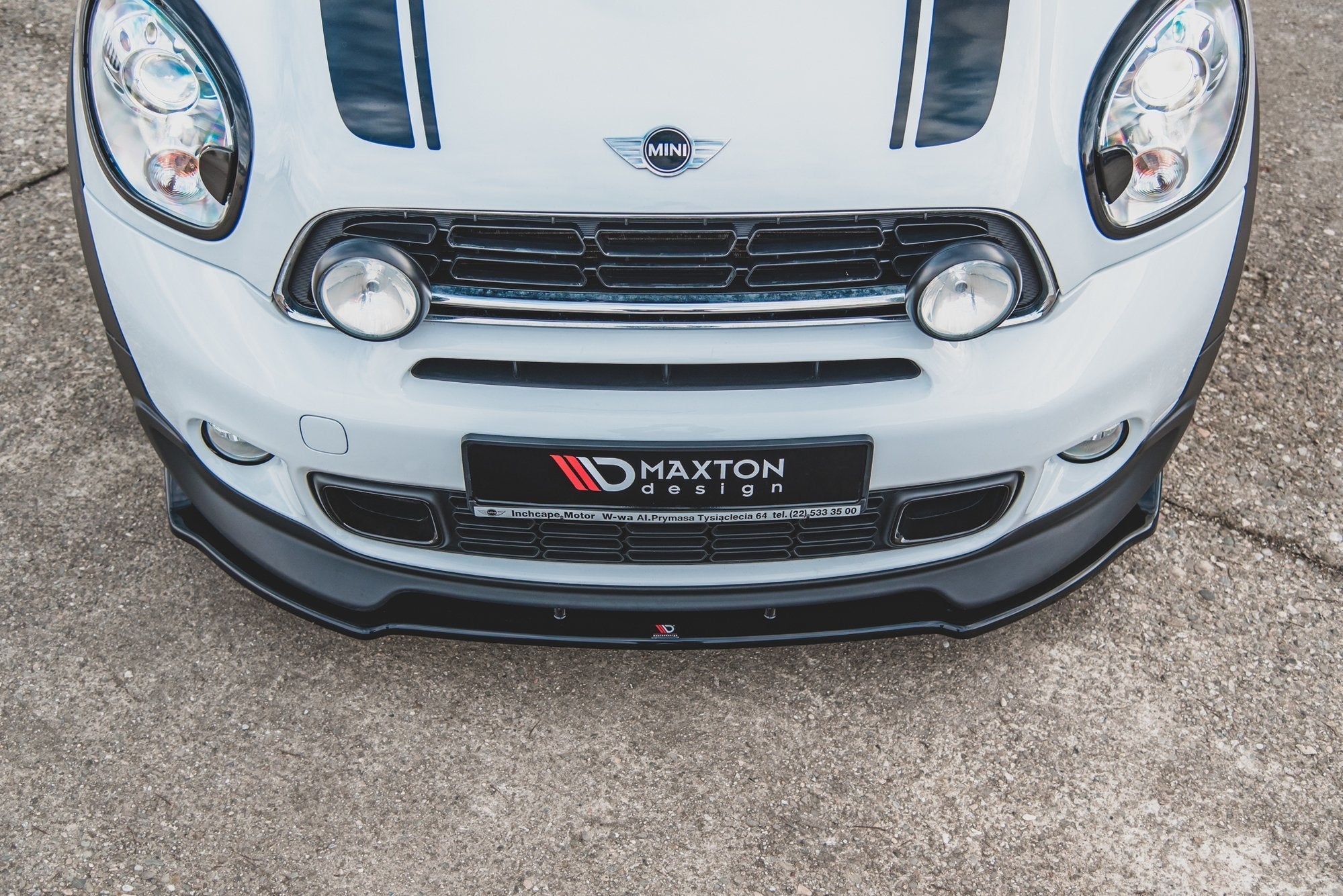 Spoiler til Mini Countryman MK1 Jcw med svart frontsplitter, ekstra lys og Maxton Design-logo.
