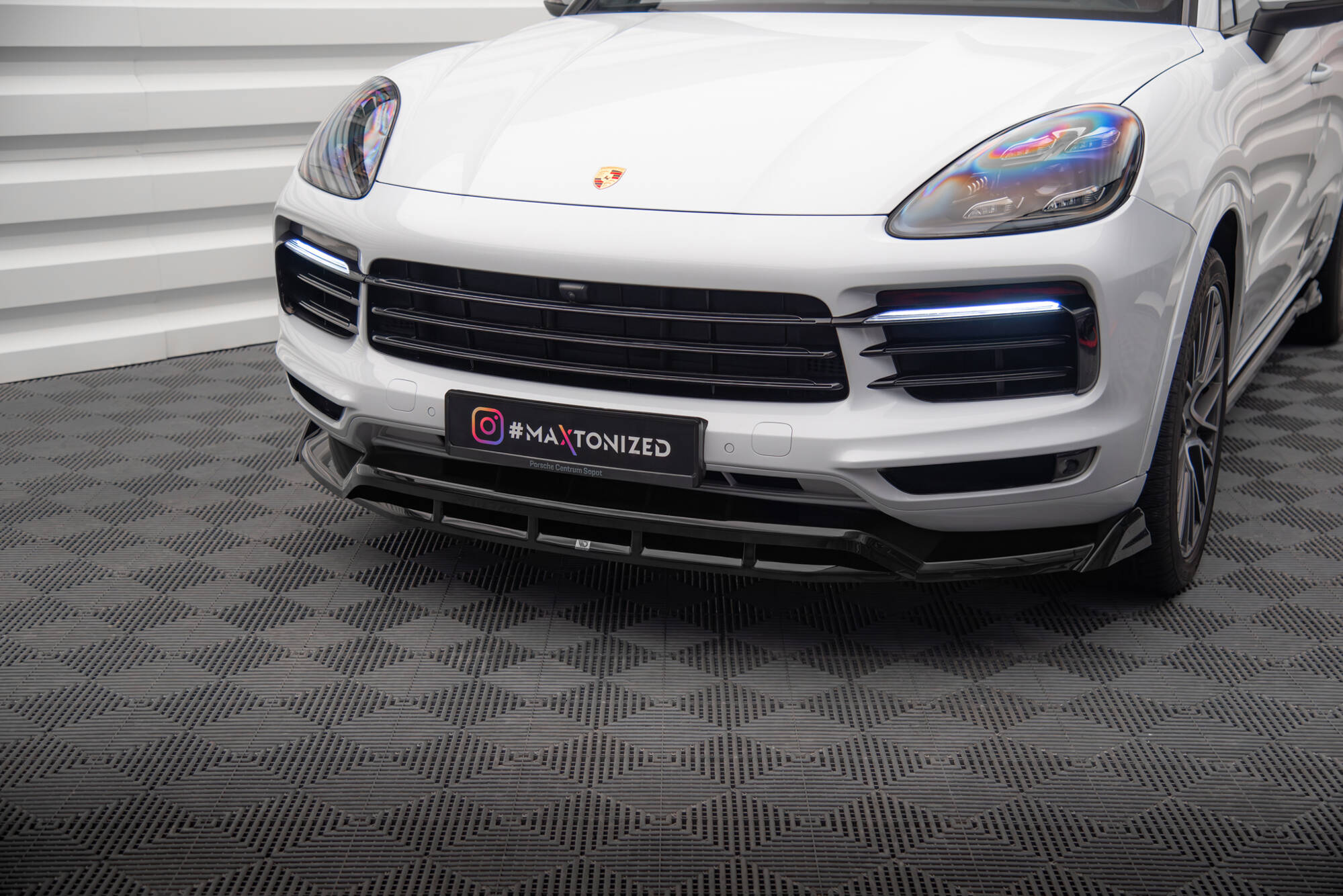 Frontspoiler på Porsche Cayenne Coupe MK3 med sort grill, LED-lys og sporty design sett fra skrå vinkel.