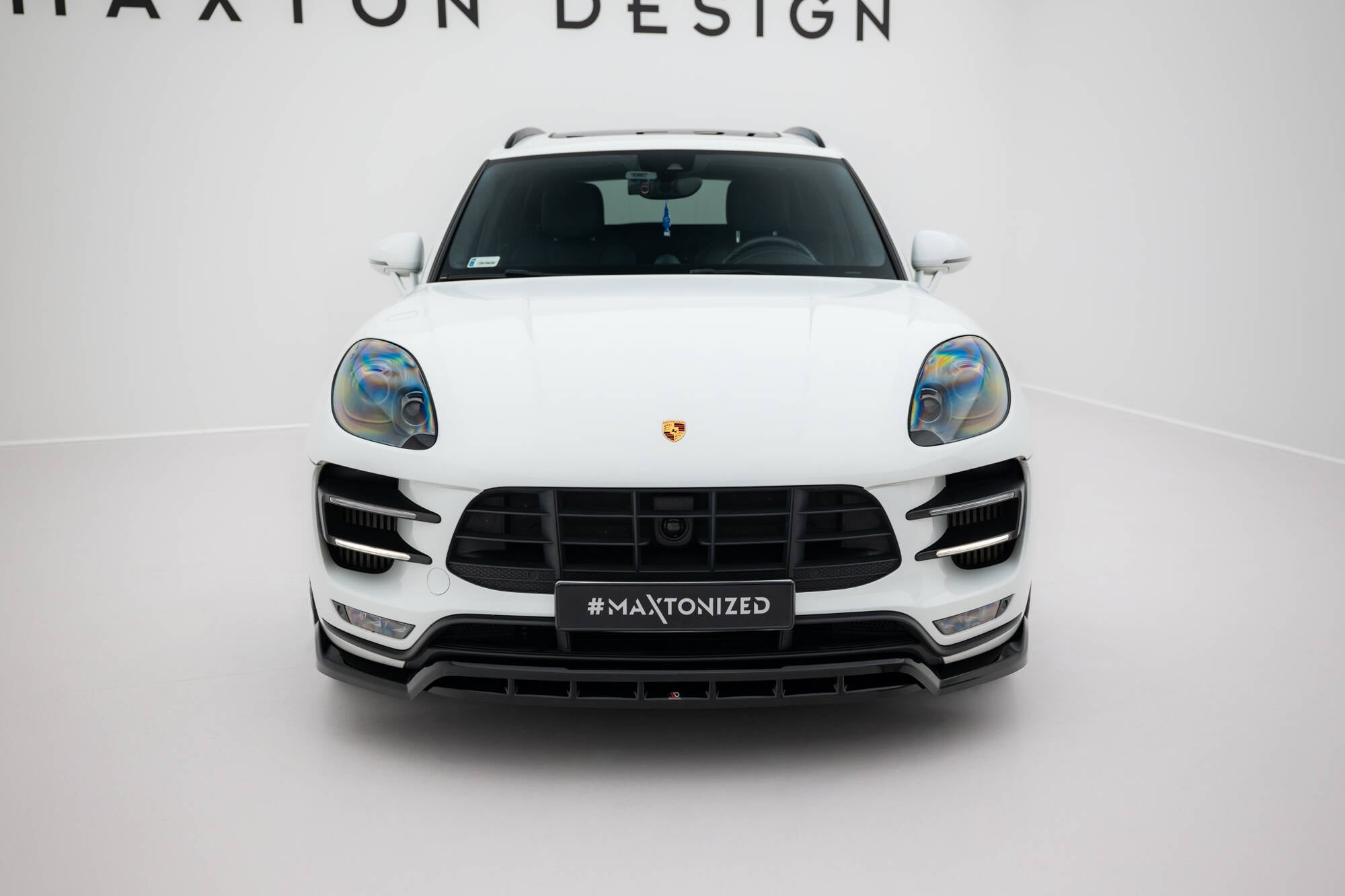 Frontleppe på Porsche Macan Turbo MK1 sett forfra med sorte detaljer og regnbue-reflekterende frontlykter.