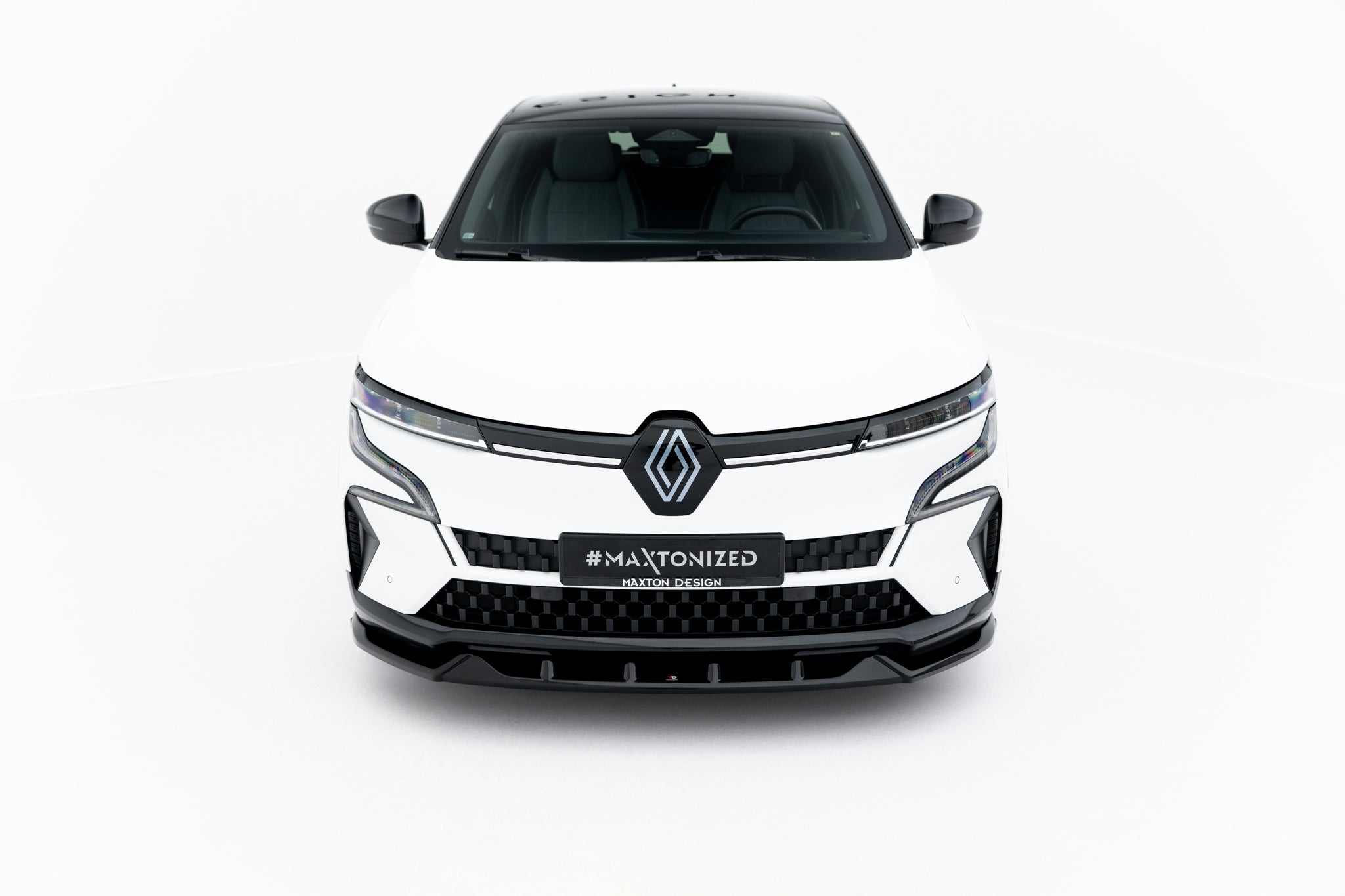 Frontleppe på Renault Megane E-Tech Electric MK1, hvit bil sett forfra med svarte detaljer og LED-lykter.