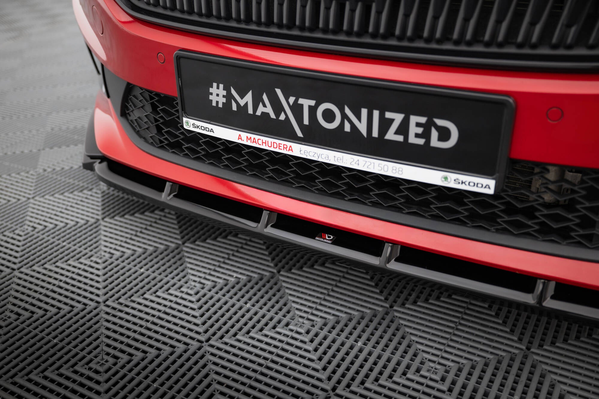 Spoiler på Skoda Fabia Monte Carlo MK4, sort frontsplitter under rød front med sort grill.