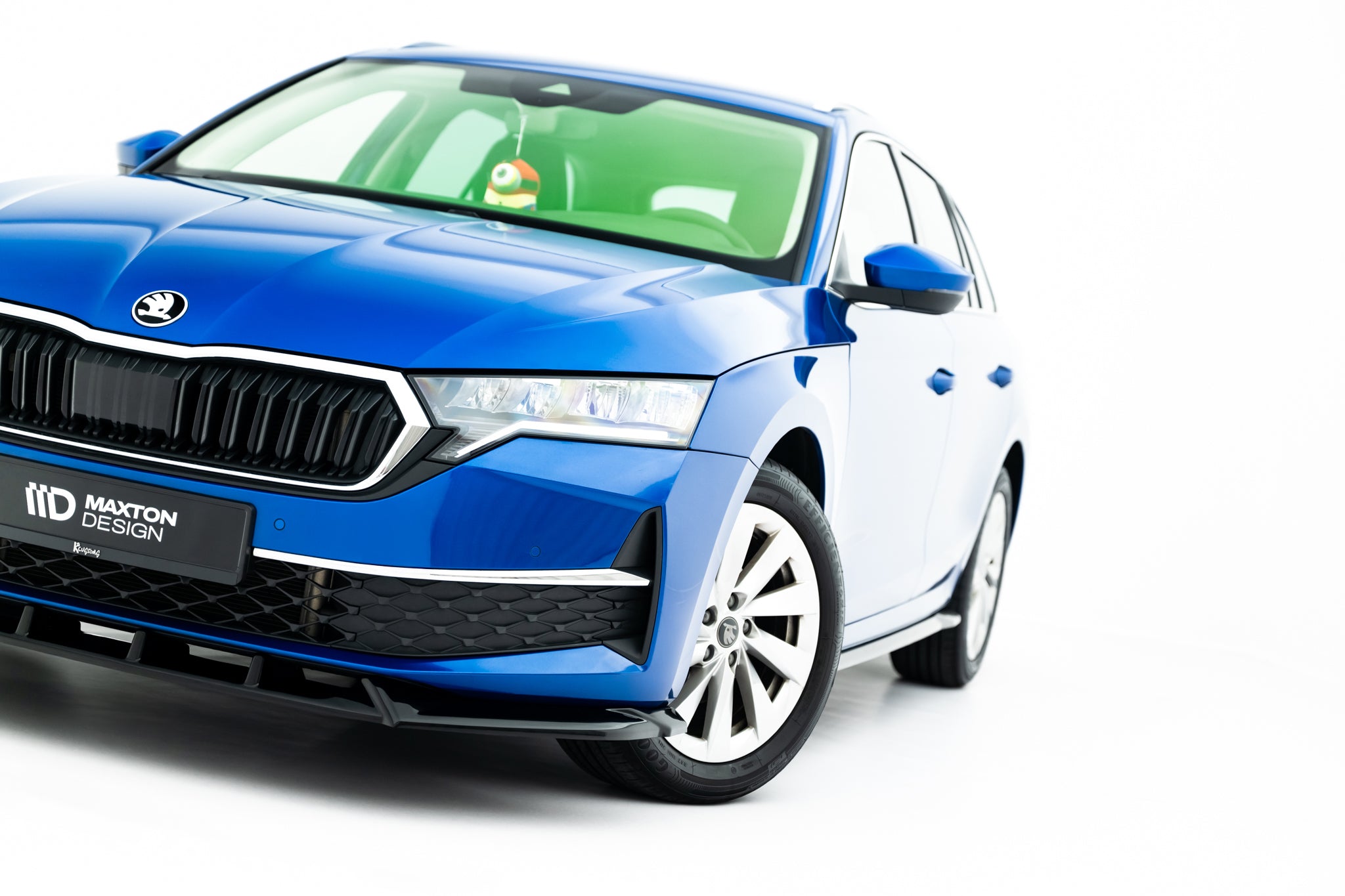 Front lip på blå Skoda Octavia MK4 Facelift med hvite felger og svart Maxton Design-skilt.