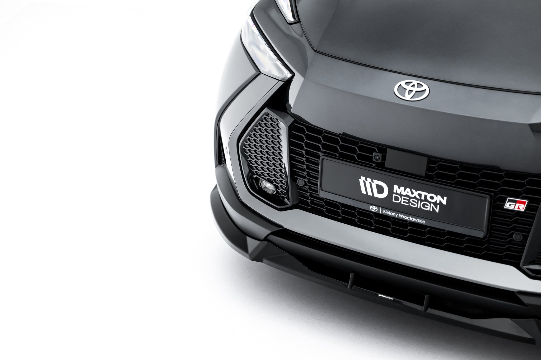 Frontleppe til Toyota C-Hr MK2, nærbilde av sort bil med grill, Maxton Design-logo og Toyota-emblem.