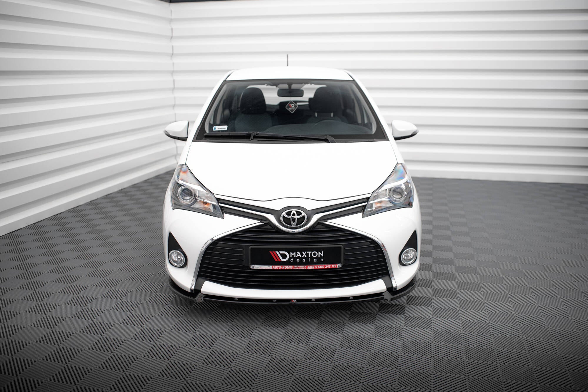 Frontleppe på Toyota Yaris MK3 Facelift, hvit bil sett forfra med svart grill og kromdetaljer.