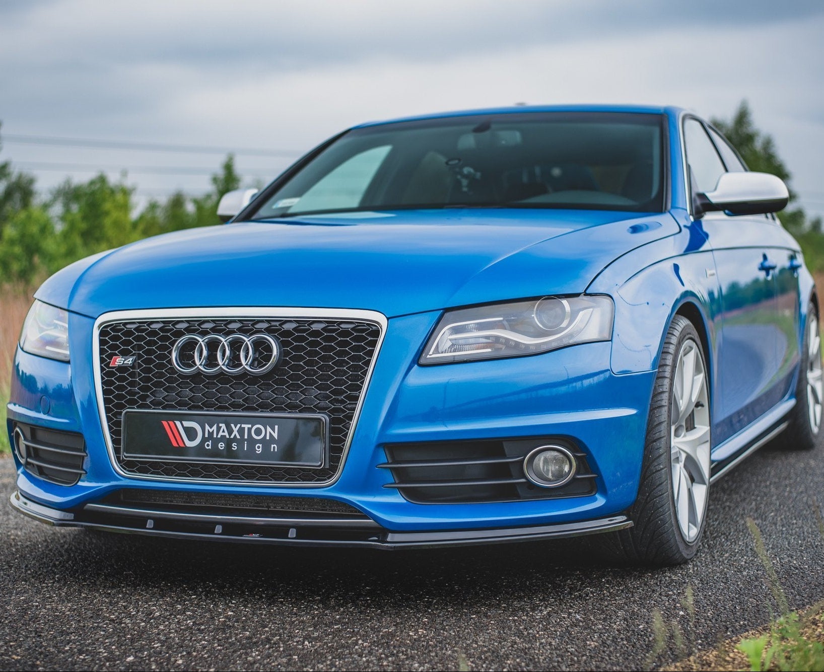 Front lip på blå Audi S4 B8 med sølv grill, Maxton Design-logo og sportslige LED-frontlykter.