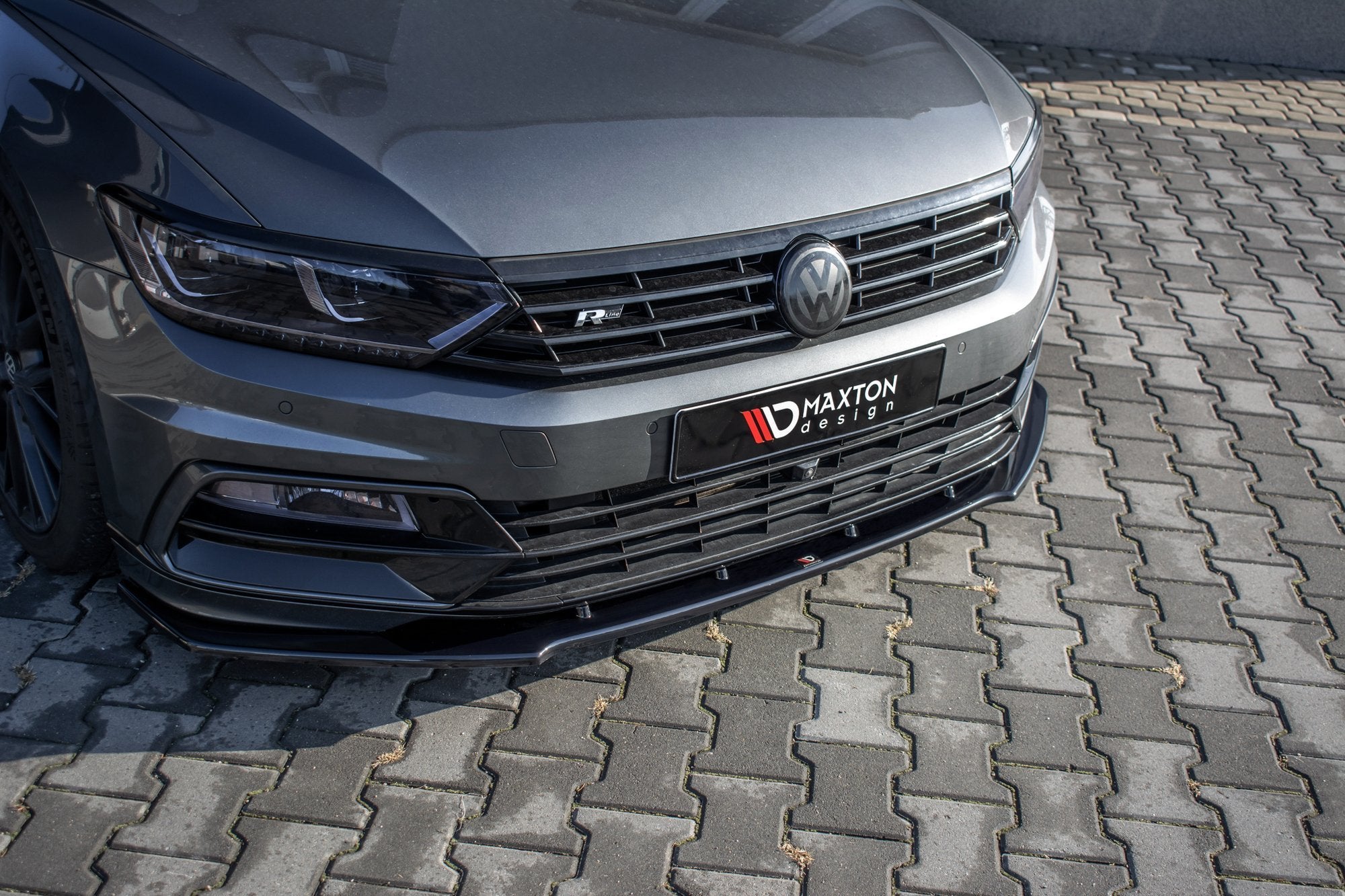 Frontleppe VW Passat R-Line B8 V.1 i grå metallic med sort frontsplitter, sett skrått ovenfra.