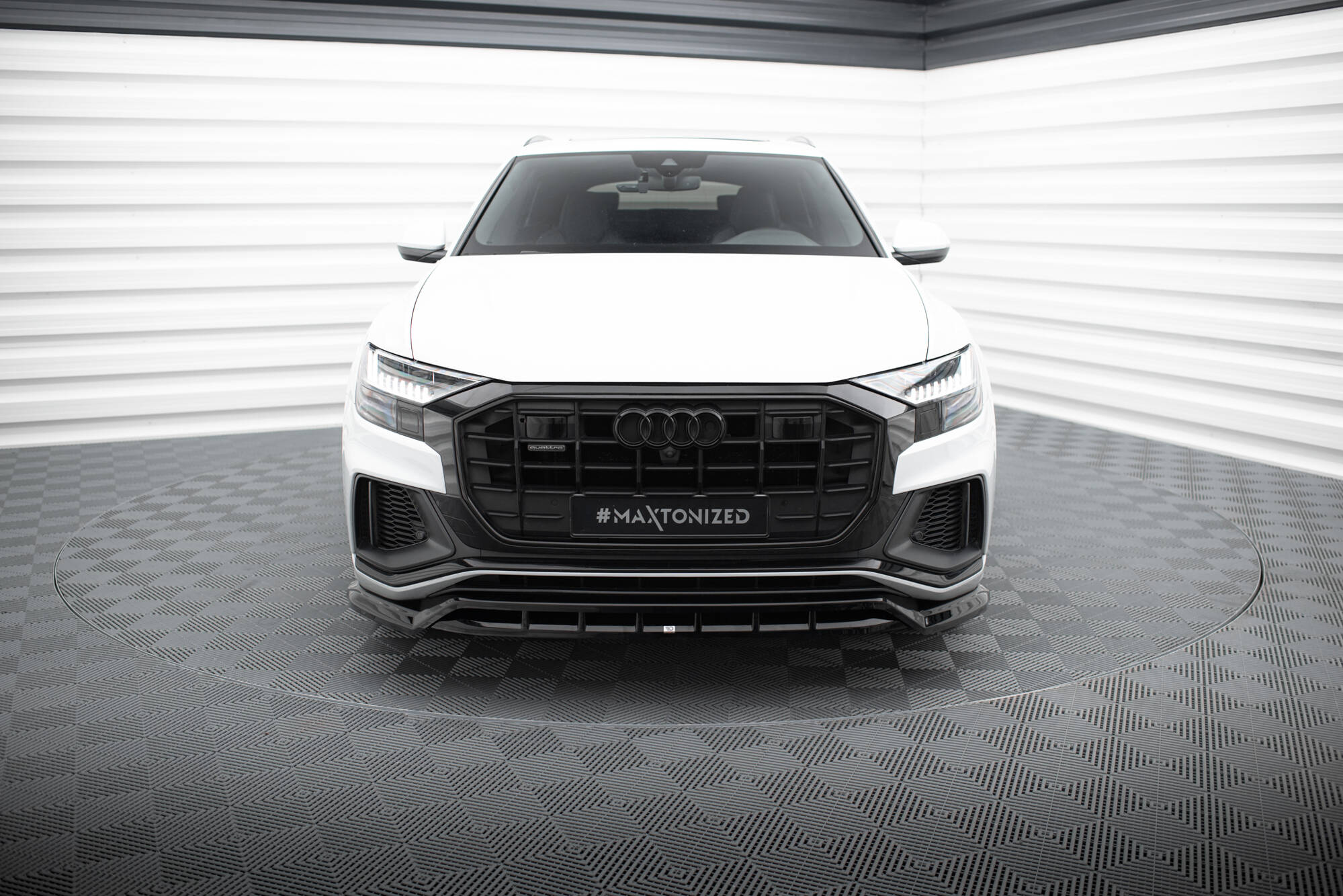 Frontleppe Audi SQ8 med sort grill, LED-frontlykter og sporty støtfanger, sett forfra i lyst studio.