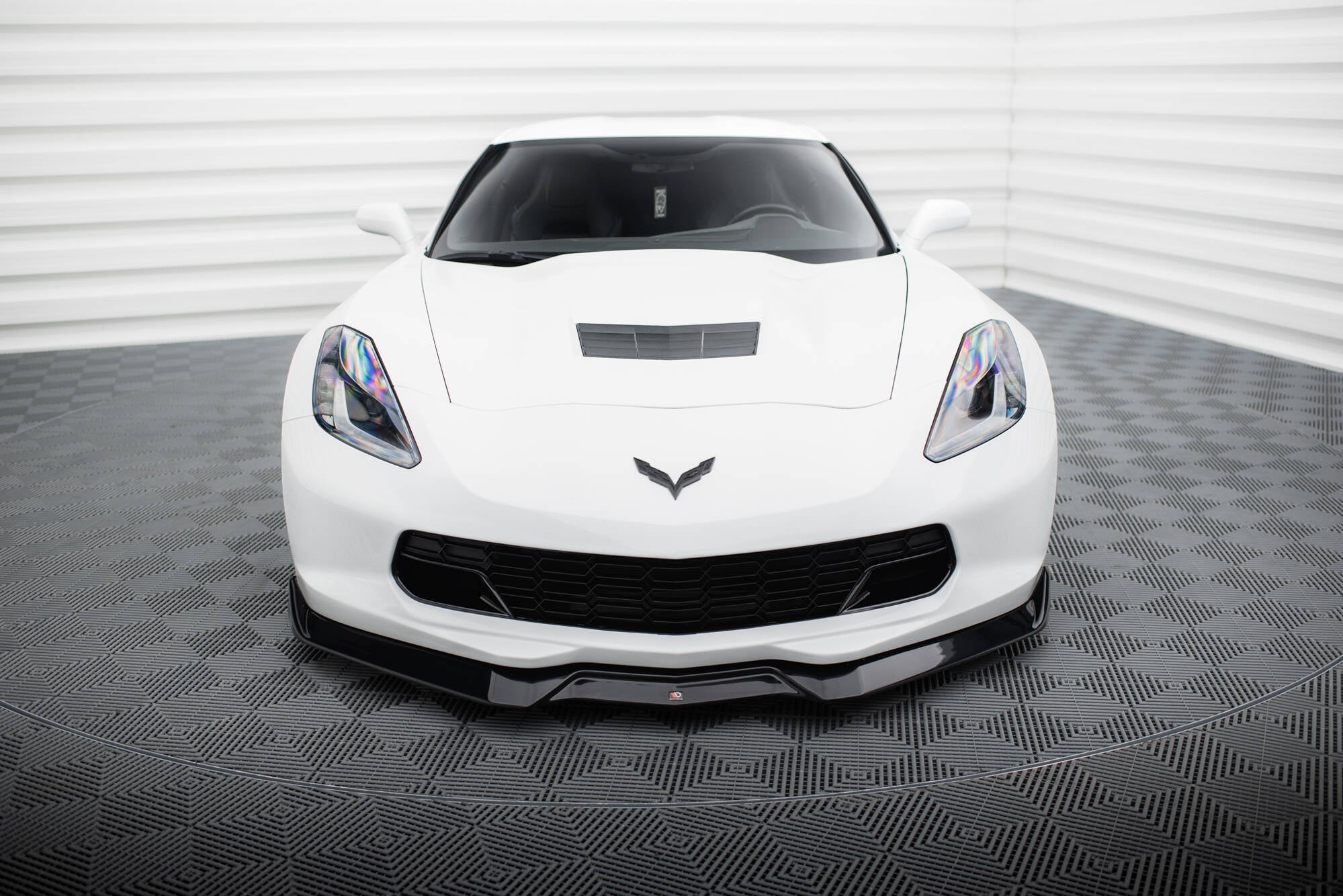 Frontleppe på hvit Chevrolet Corvette Stingray C7 med sorte detaljer og aerodynamisk frontstøtfanger.