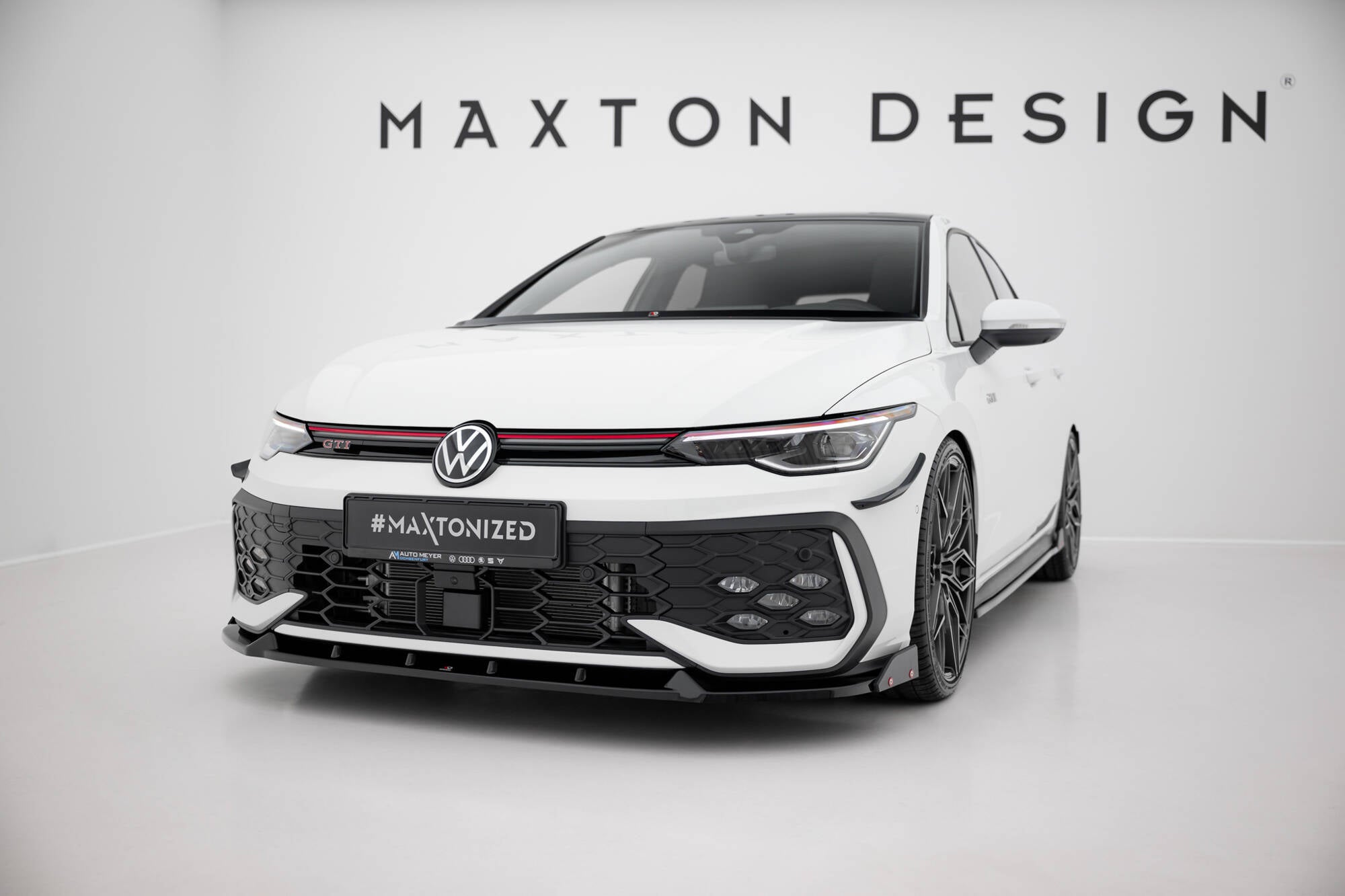 Frontspoiler VW Golf MK8 Facelift GTI med svart design, røde detaljer og Maxton Design-logo i studio.