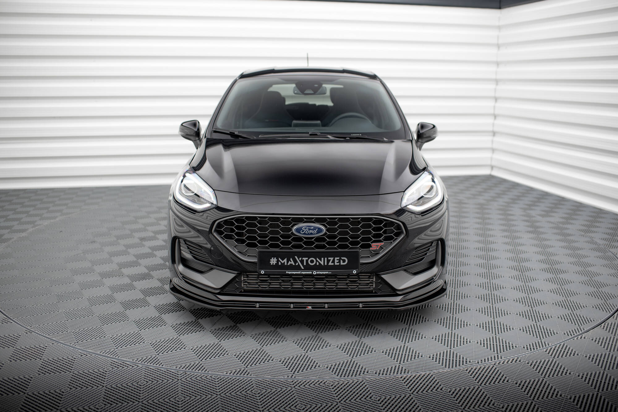 Frontleppe på Ford Fiesta MK8 Facelift med sort bikubemønstret grill og sportslig støtfanger.