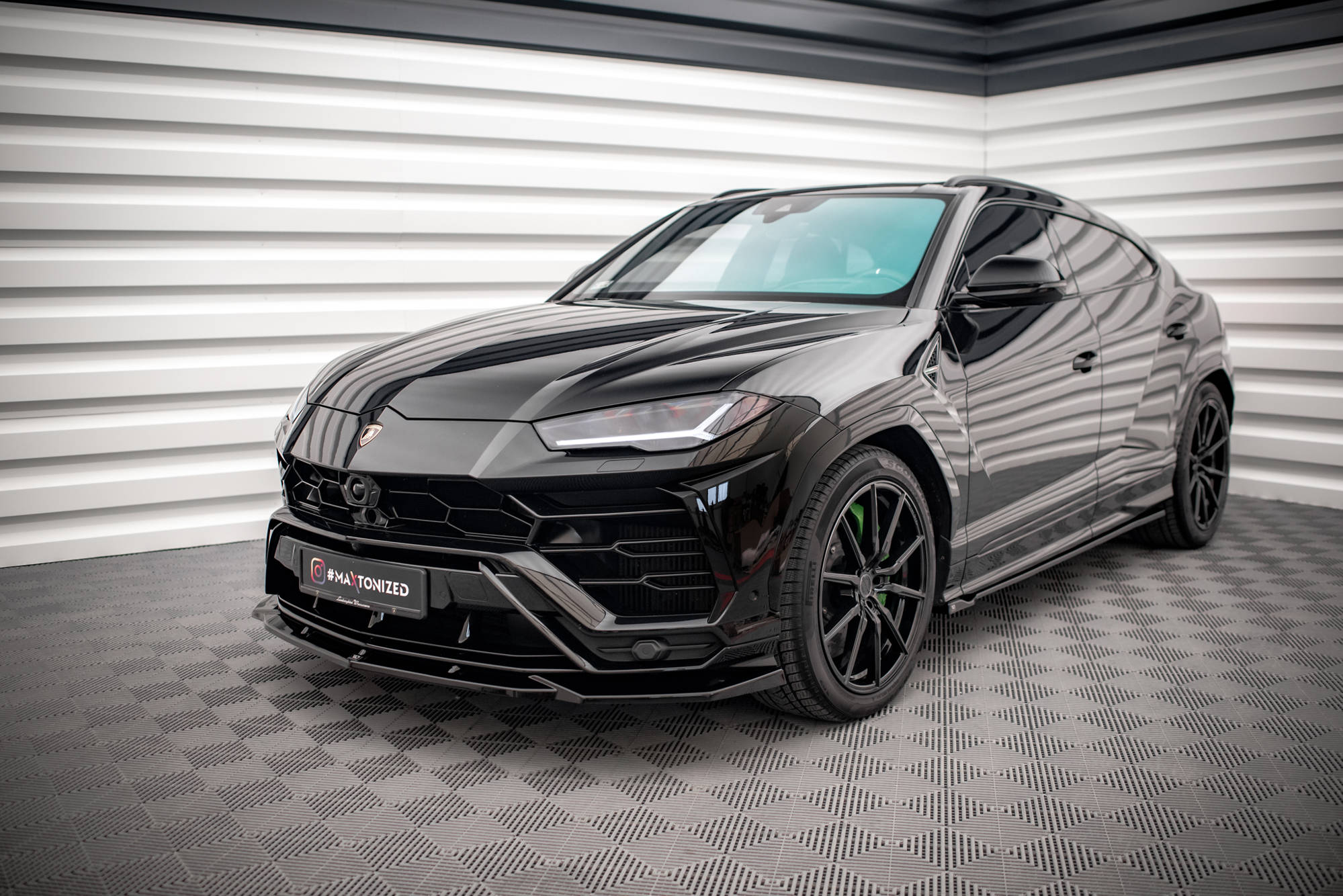 Frontspoiler Lamborghini Urus MK1 V.2 sort SUV med grønne bremsekalipere, sett fra siden og forfra.
