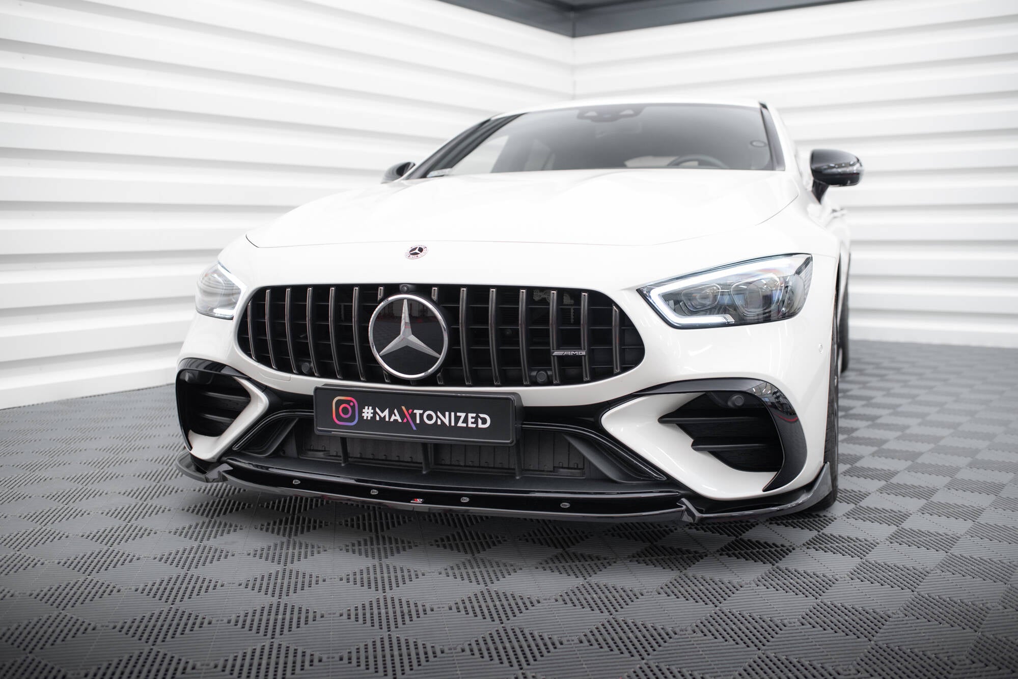 Frontspoiler på Mercedes GT 43 4 Dør Coupe med sort grill og sportslig frontleppe i showroom.
