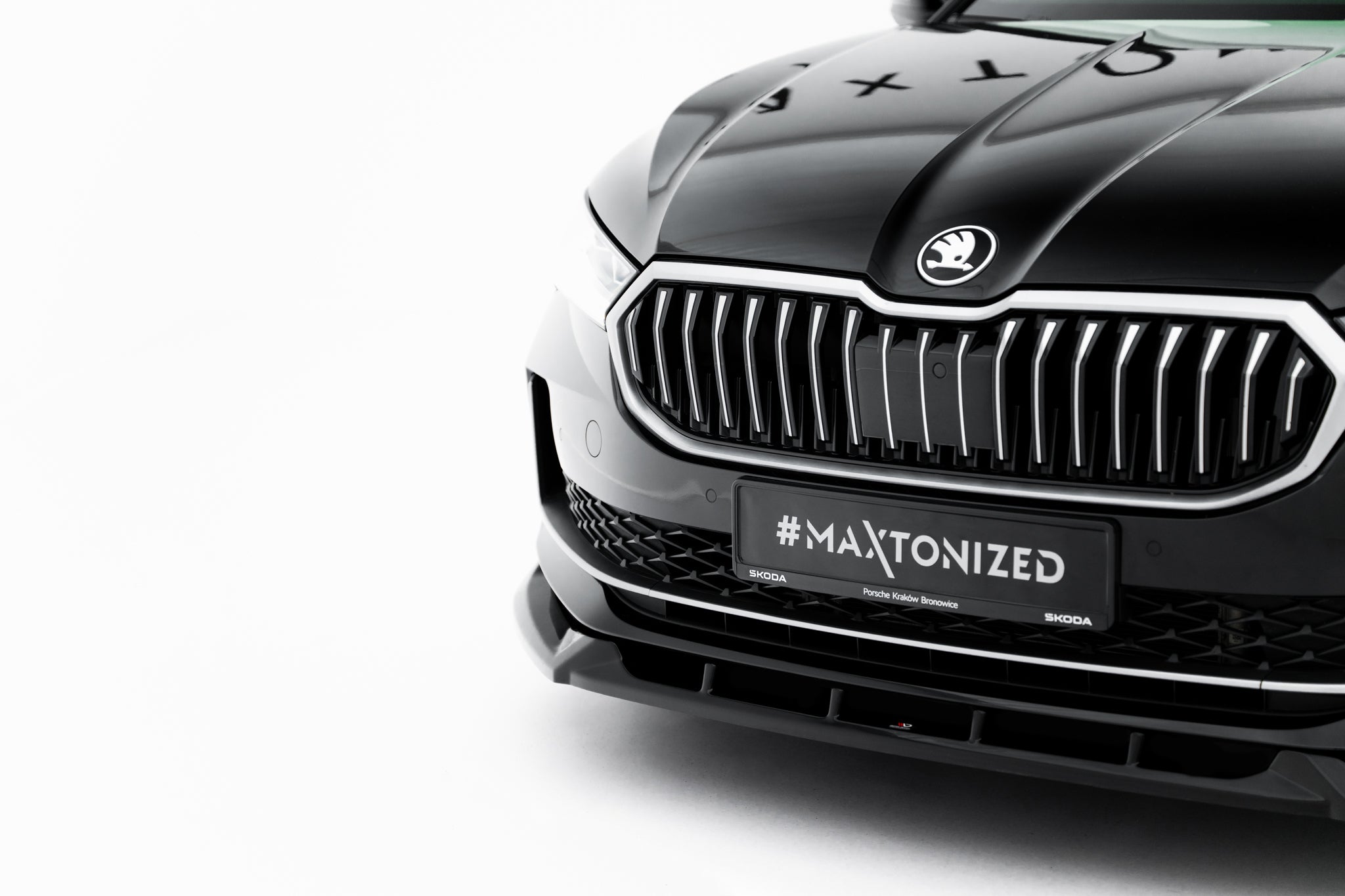 Front splitter til Skoda Superb MK4 V.2, blank svart med kromdetaljer og #MAXTONIZED på skiltet.