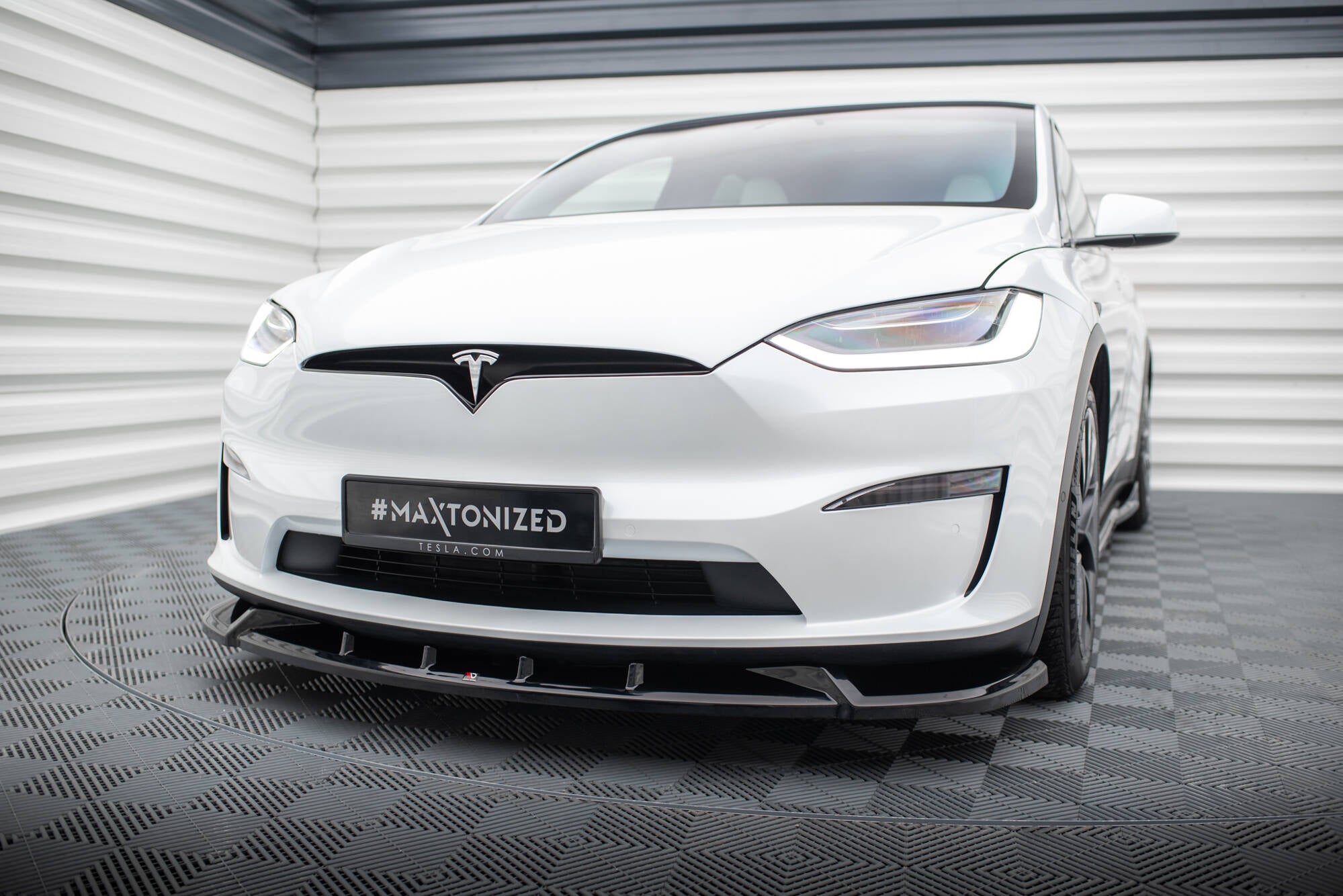 Frontspoiler Tesla Model X MK1 Facelift V.2 på hvit bil med sorte detaljer sett skrått forfra.