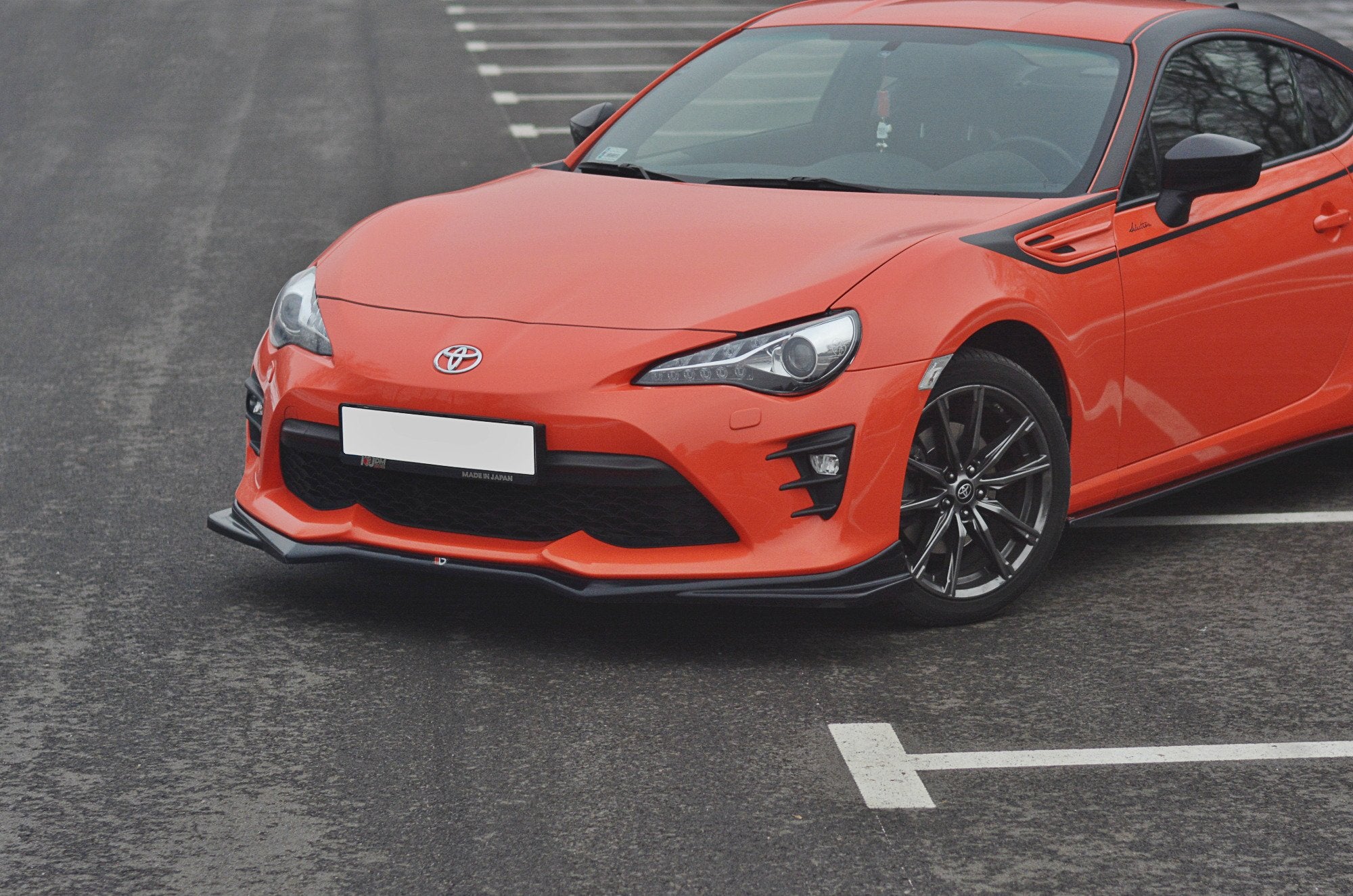 Frontleppe på Toyota GT86 Facelift V.2, oransje sportsbil med sorte detaljer og mangeeikede felger.
