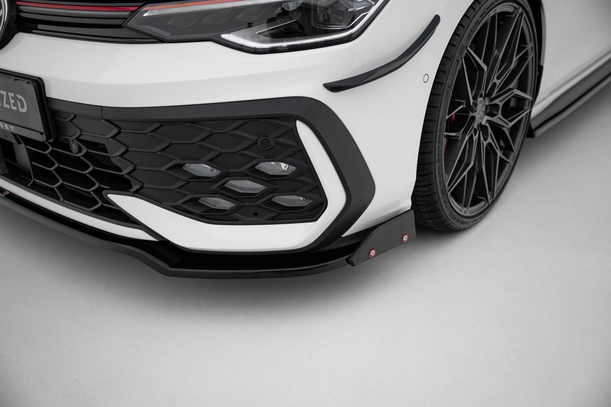Spoiler på VW Golf GTI MK8 Facelift med sorte detaljer, sportslig felg og bikubemønstret grill.