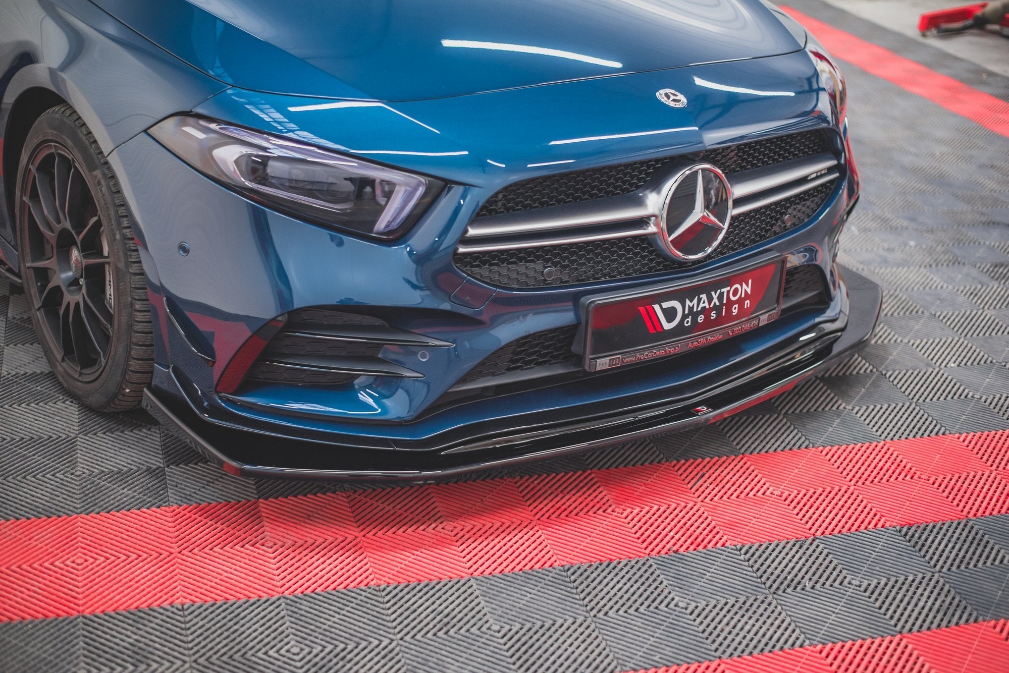 Spoiler Mercedes A35 AMG Aero W177 V.3 på blå bil med svart, glanset frontsplitter sett fra skrå vinkel.