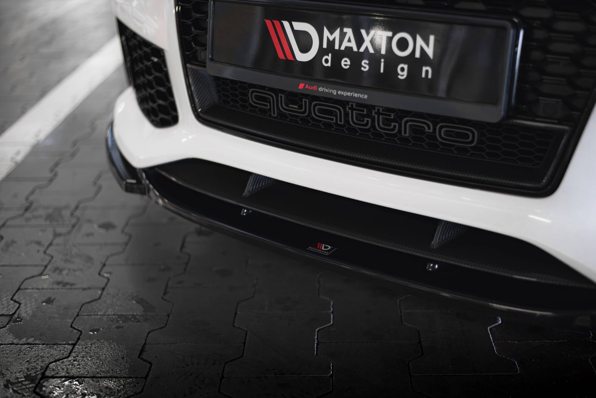 Front splitter Audi RS7 C7 V.4 i karbon-look montert på hvit bil med synlig honeycomb-grill.