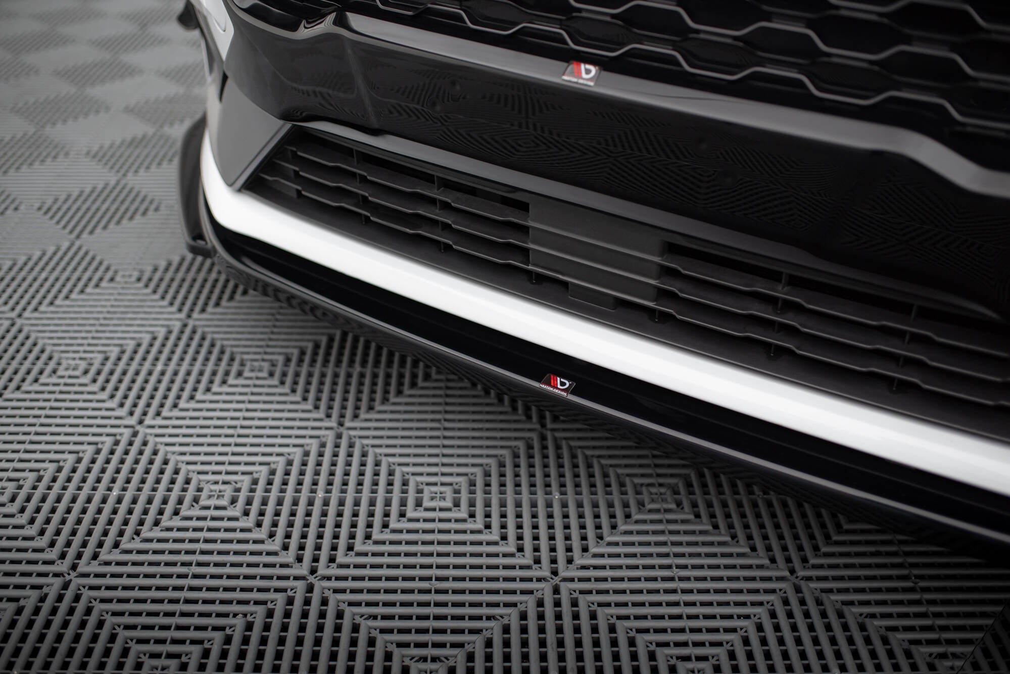 Spoiler til Ford Fiesta MK8 St V.4 vist som nærbilde av frontfanger med sorte og hvite detaljer.