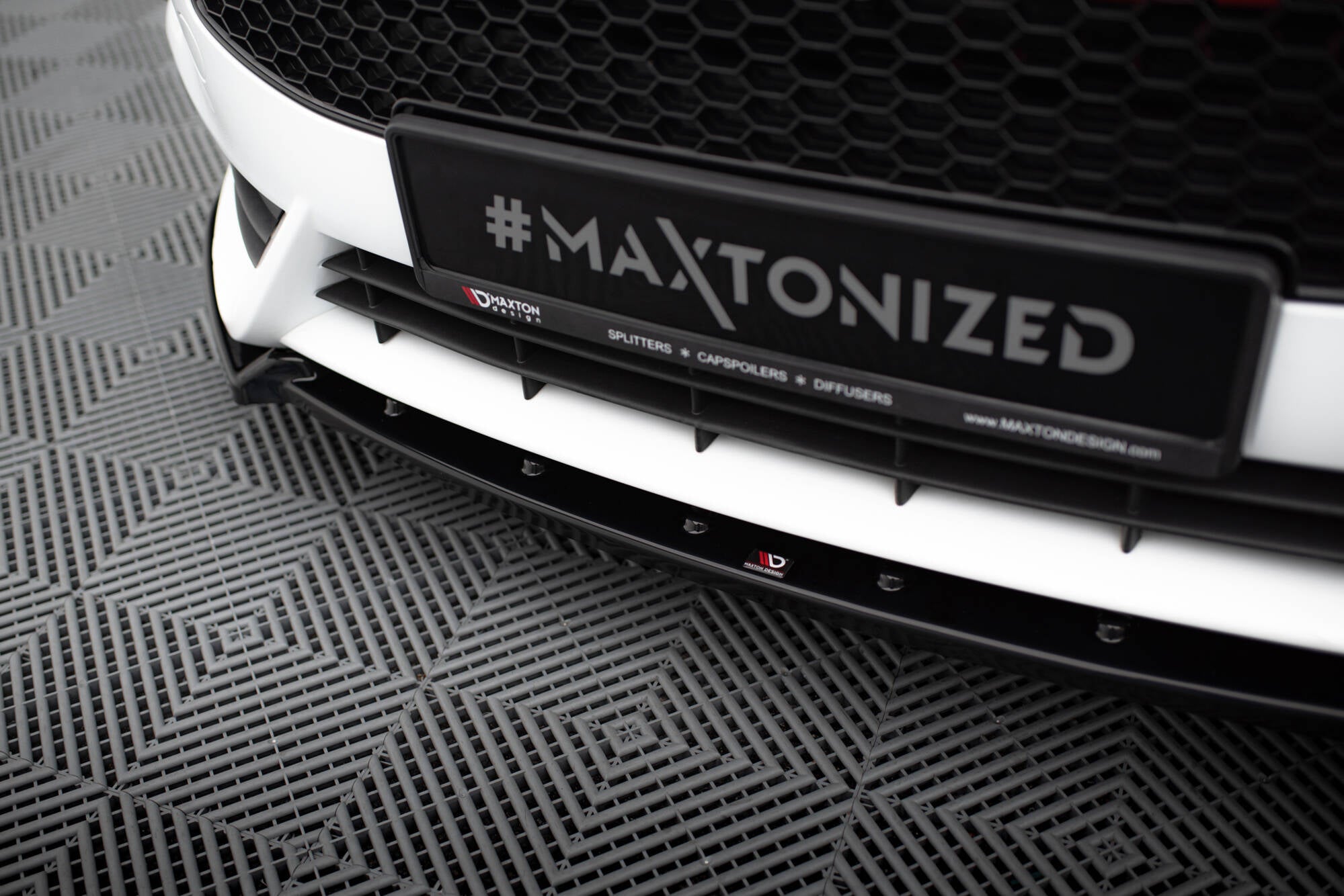 Spoiler til Ford Fiesta St MK7 Facelift V.4 i sort blank finish med Maxton Design-logo på hvit bil.