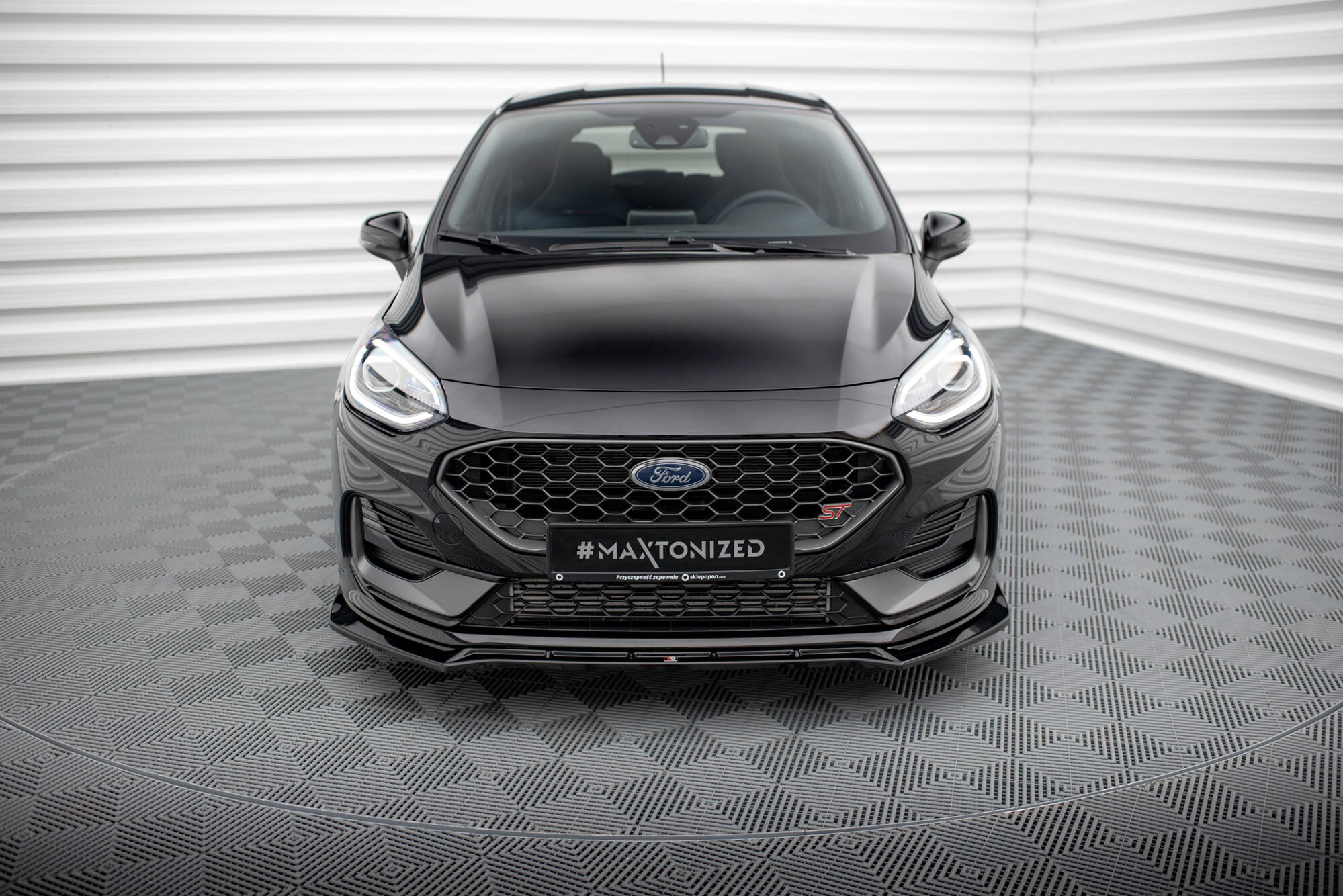 Frontleppe på Ford Fiesta MK8 Facelift ST med svart grill og LED-lys, fotografert rett forfra.