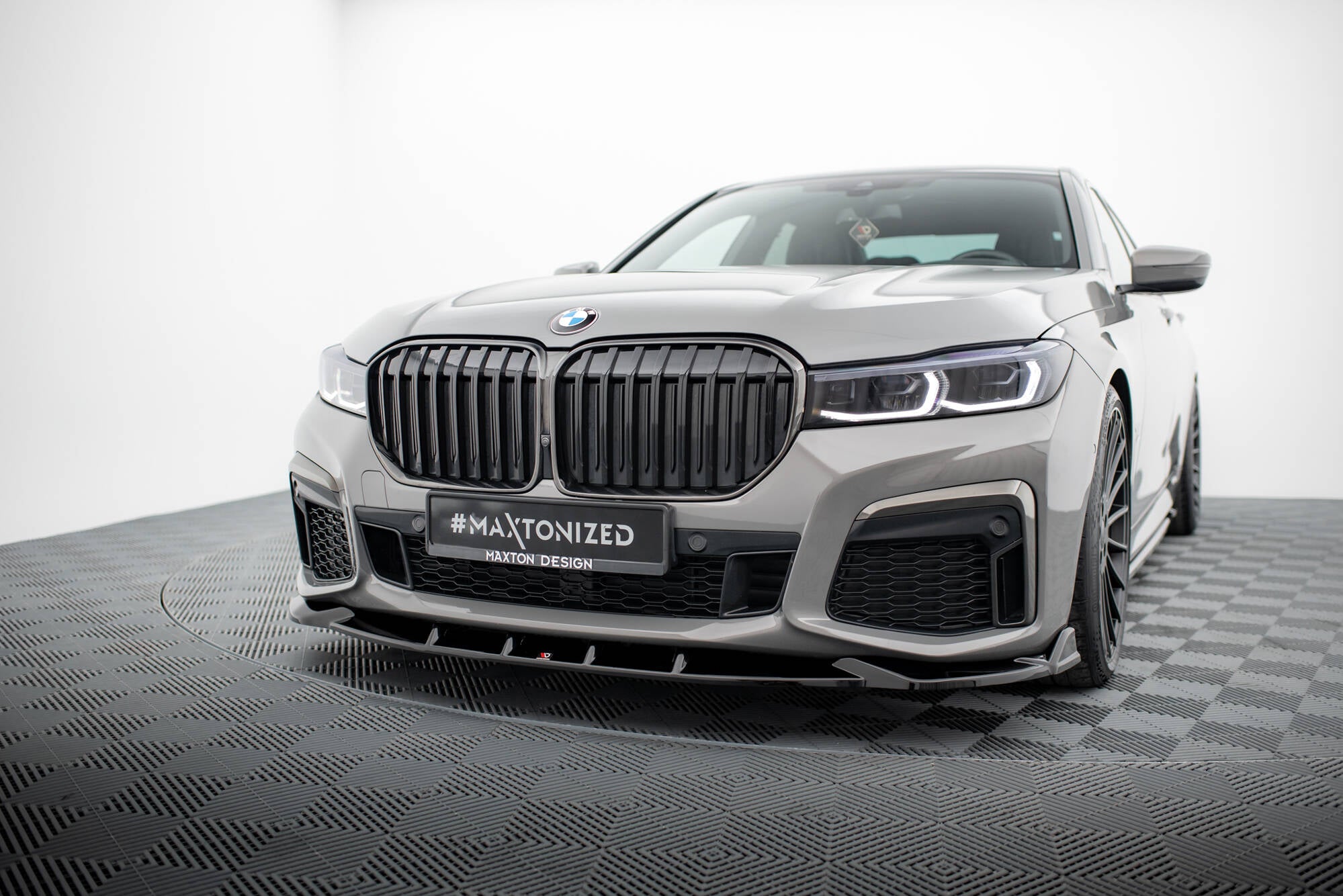 Frontspoiler BMW 7 M-Pakke G11/G12 Facelift V.5 på sølvgrå bil med sorte griller og LED-frontlykter.