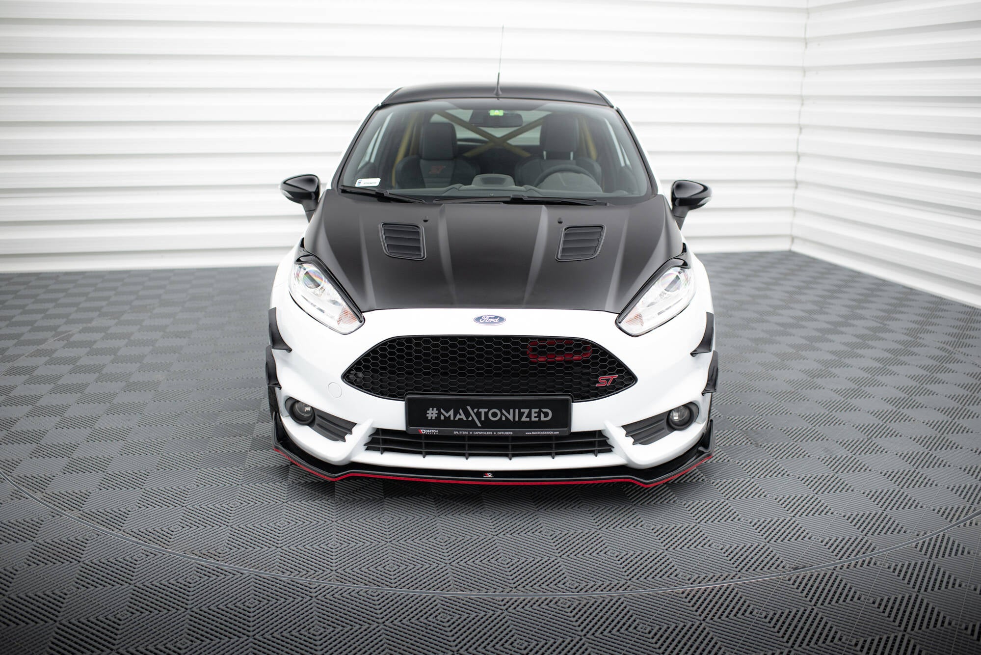 Frontleppe på Ford Fiesta St MK7 Facelift V.5, hvit bil med sort panser og røde detaljer, sett forfra.