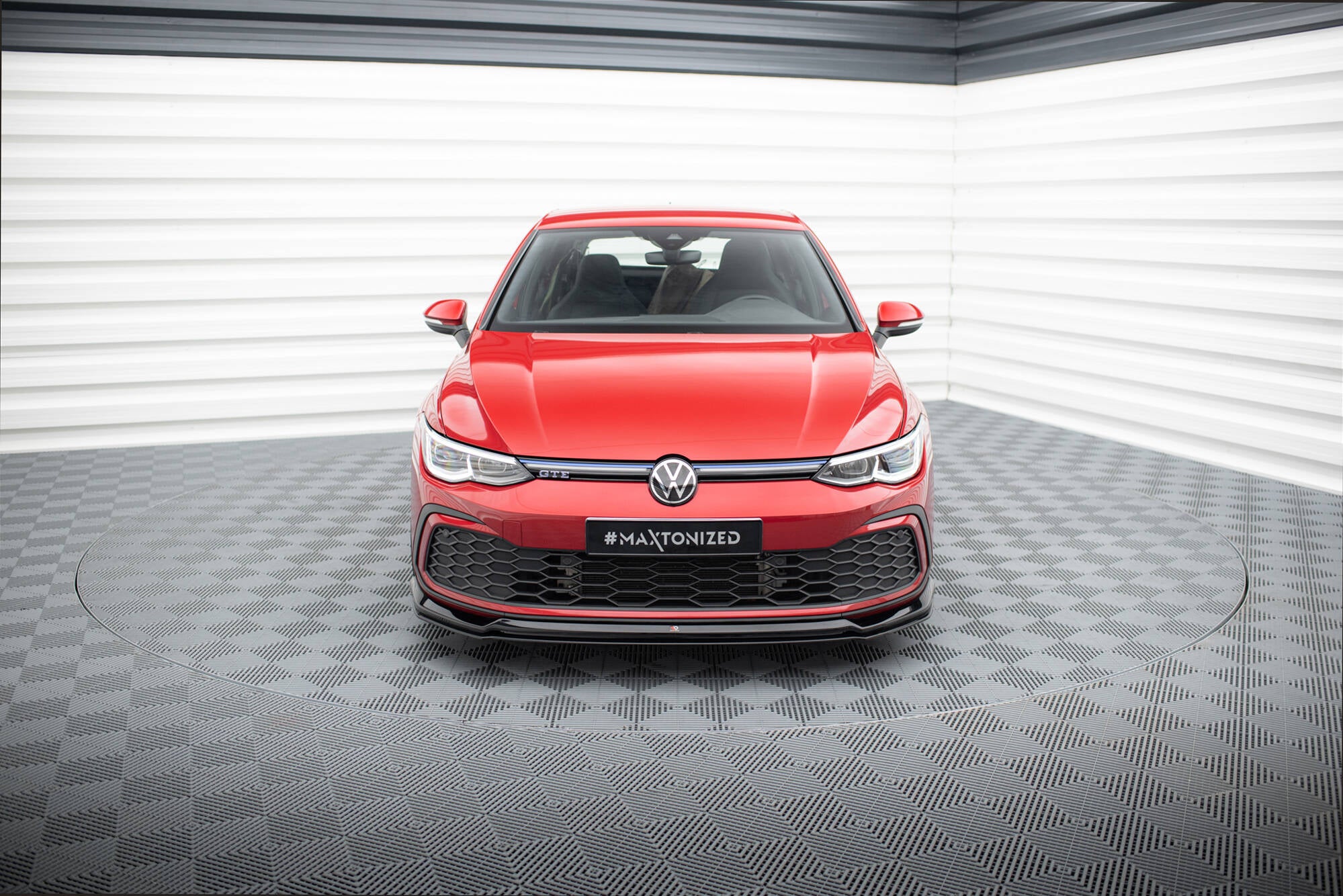 Frontleppe på VW Golf MK8 GTI med sort grilldetalj, rød lakk og moderne bakgrunn.