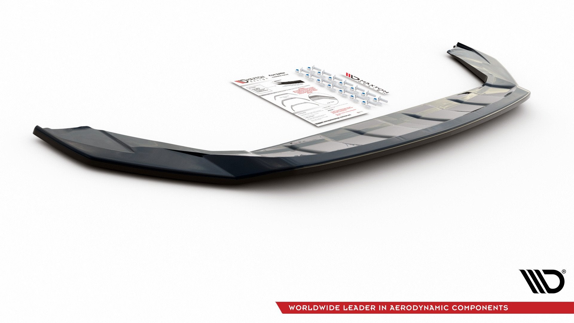 Front lip til VW T-Cross i svart, blank utførelse med monteringsutstyr og instruksjoner bak på hvit bakgrunn.