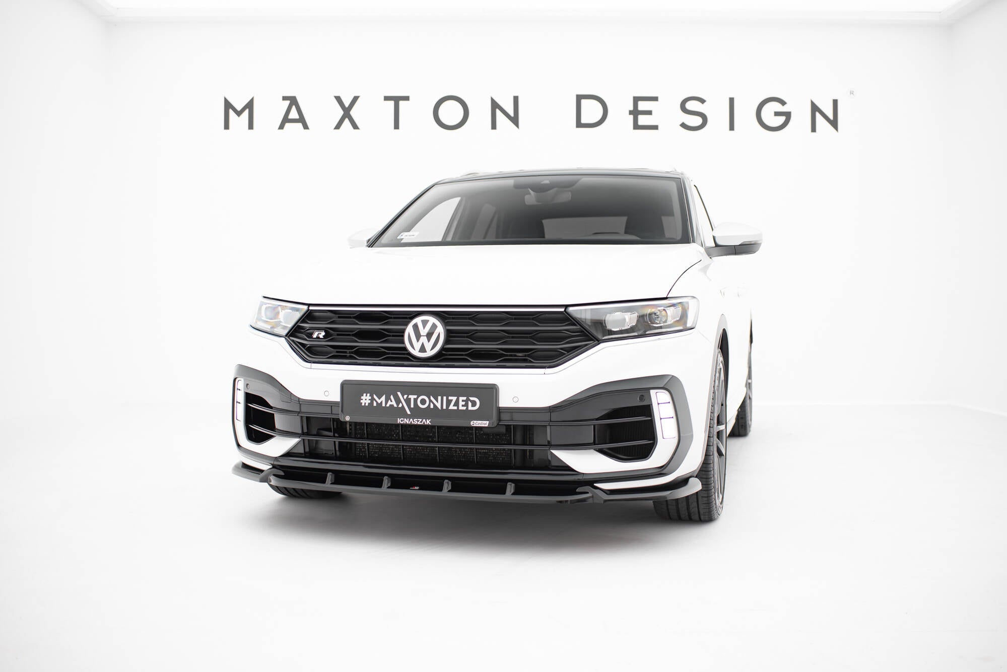 Frontspoiler til VW T-Roc R MK1 montert på hvit bil med sort grill i lyst studio.