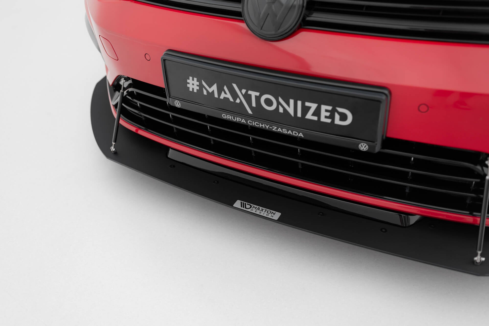Frontleppe VW Golf 7 R med svart plastspoiler, metallstøttestag og Maxton Design-logo.