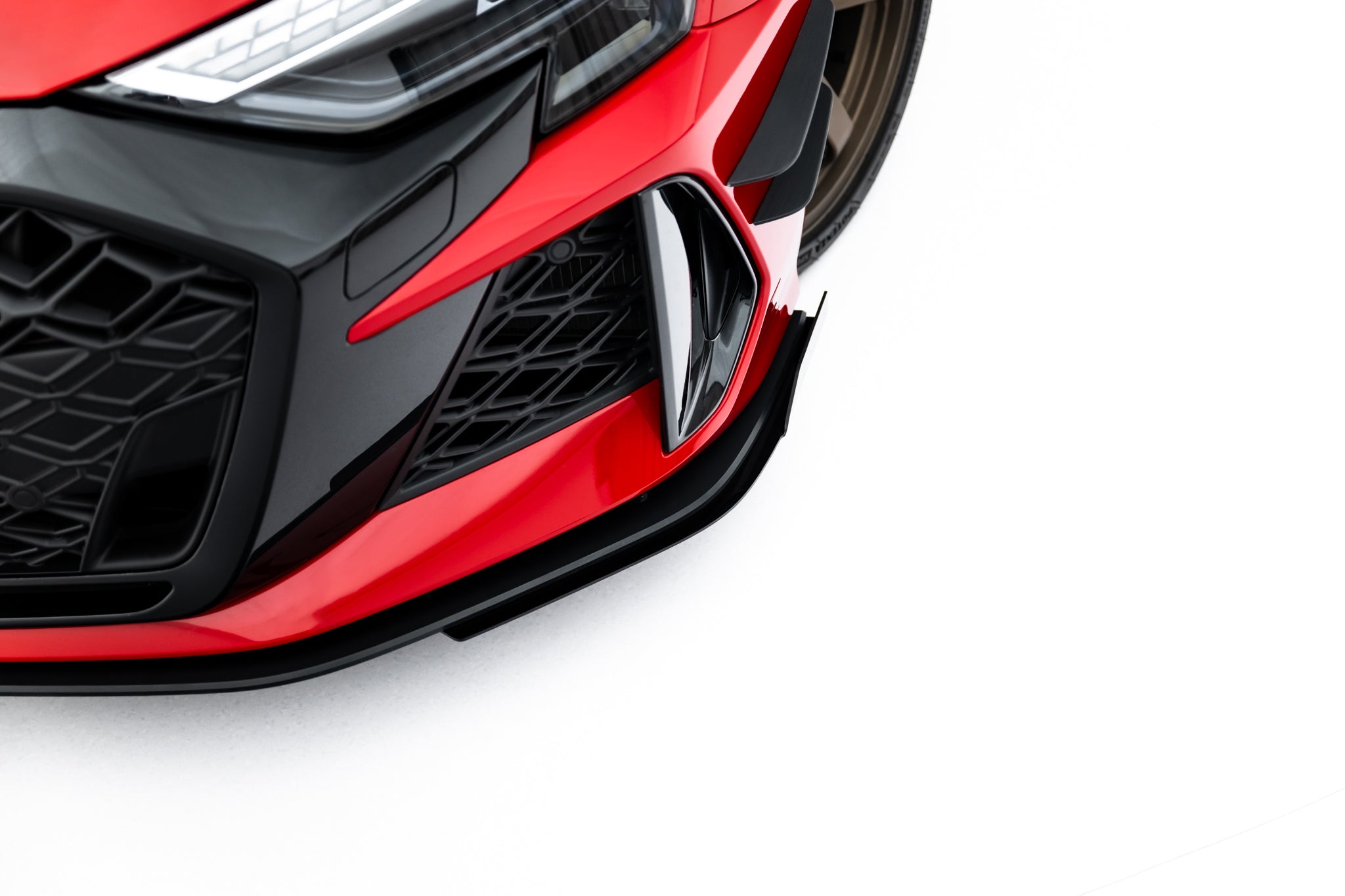 Front splitter Audi RS3 Sedan 8Y Facelift med sorte detaljer og markert luftinntak, sett fra siden.