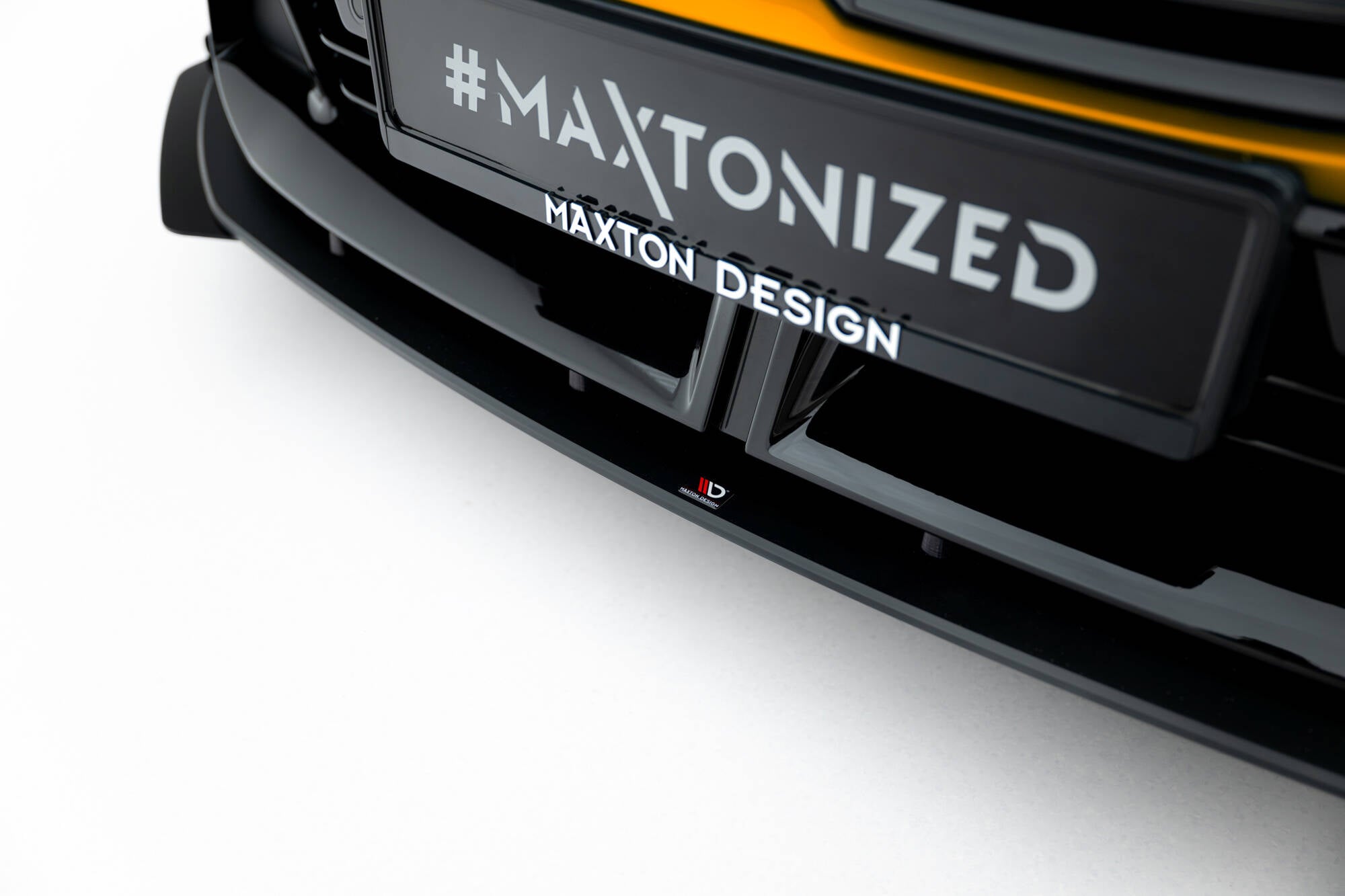 Spoiler til BMW F70 1 M-Pakke med blank sort finish, sett forfra med Maxton Design-logo.