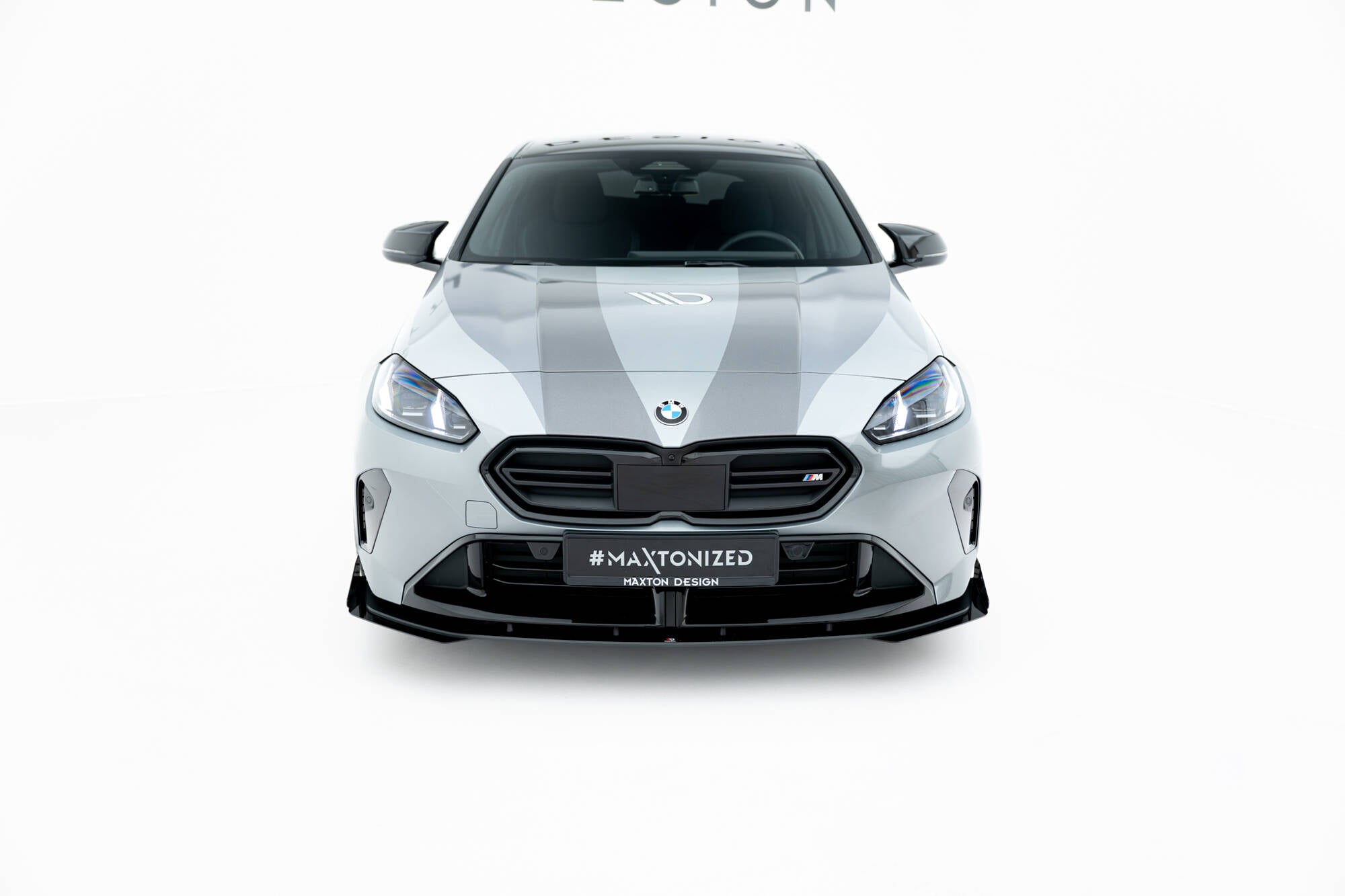 Front lip på BMW F70 M135I med svarte flaps, markante LED-lykter og synlig BMW-logo.