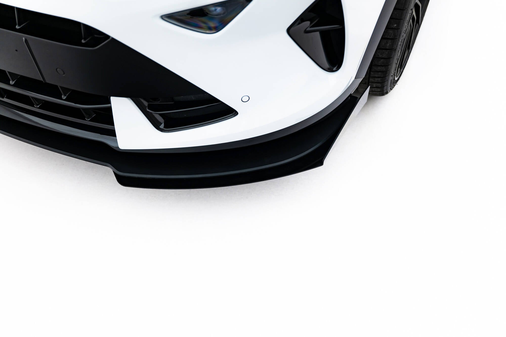 Front splitter Cupra Formentor MK1 Facelift med svarte flaps på hvit frontfanger, sett fra høyre hjørne.