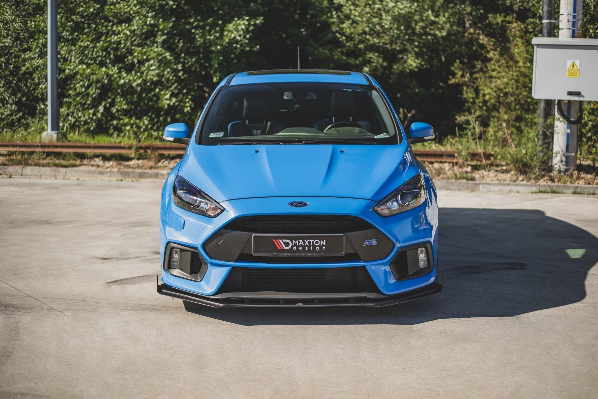 Frontspoiler til Ford Focus RS MK3 10mm V2 montert på blå sportsbil med svarte detaljer og RS-merke.
