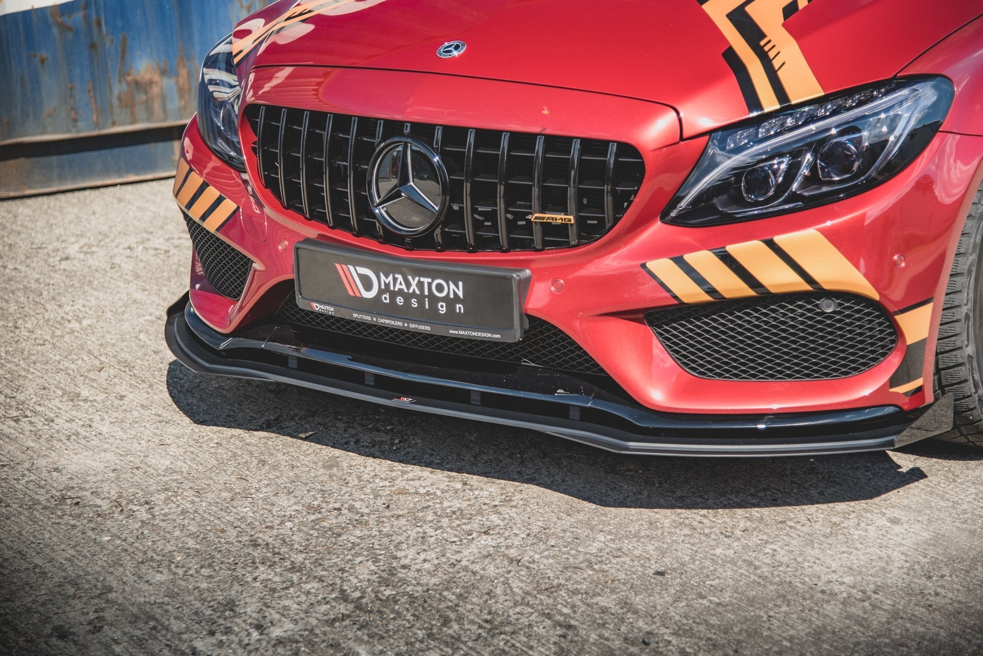 Front splitter på Mercedes C43 Coupe C205, sort plast under rød front med sorte og oransje detaljer.