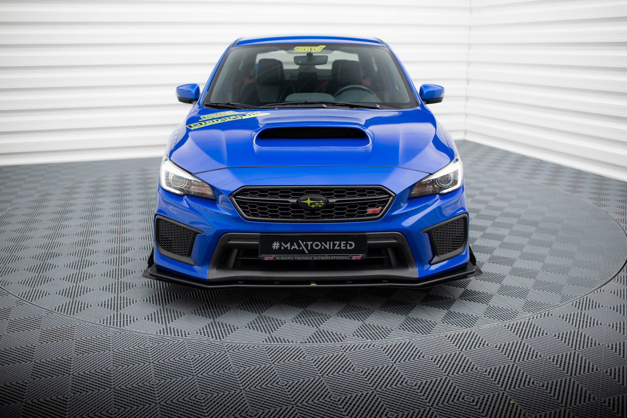 Frontleppe på Subaru WRX Sti MK1 Facelift med svarte detaljer, blå lakk og gule dekaler foran.