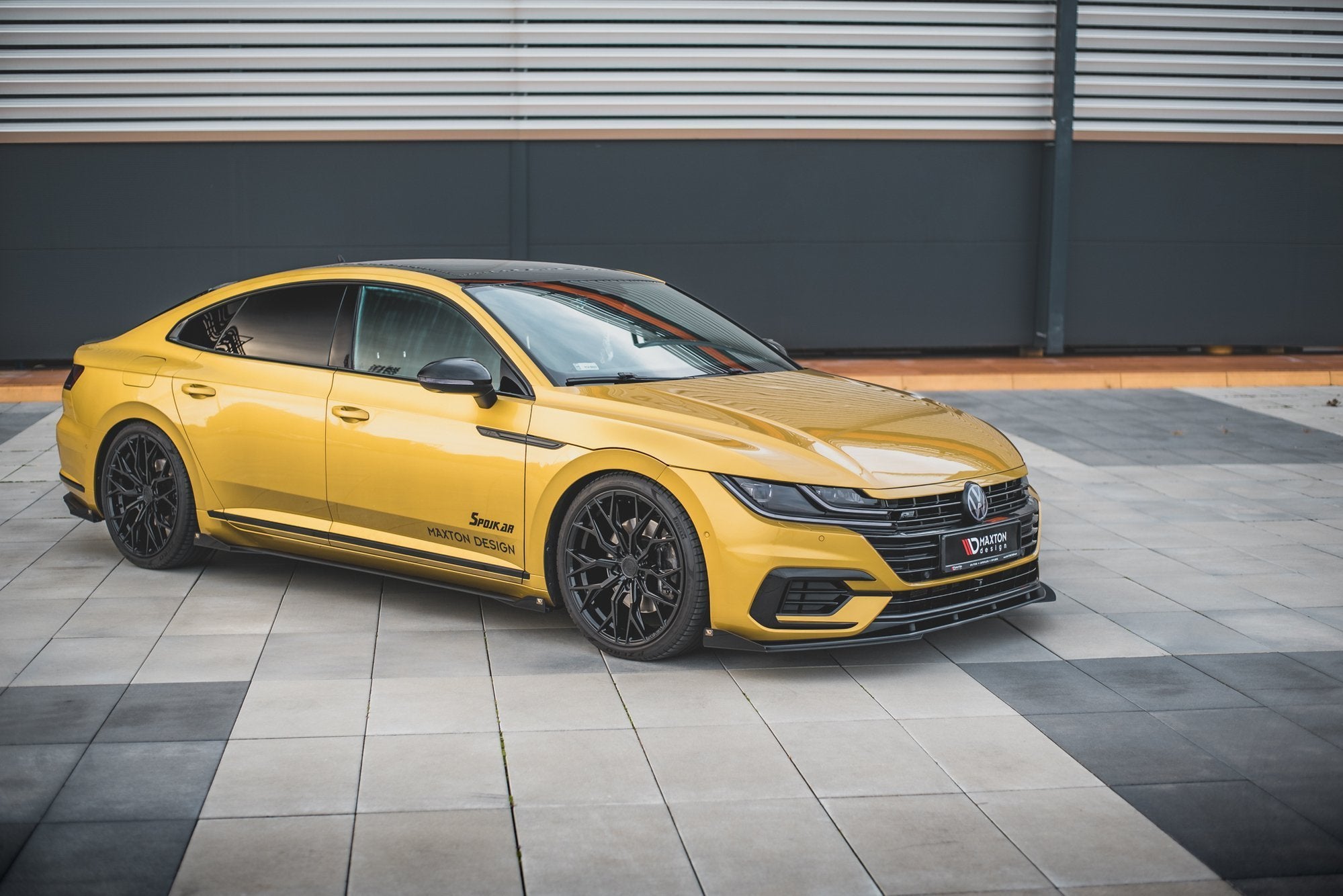 Front splitter på gul VW Arteon R-Line RS med sorte detaljer og svarte felger, Maxton Design-logo på døren.